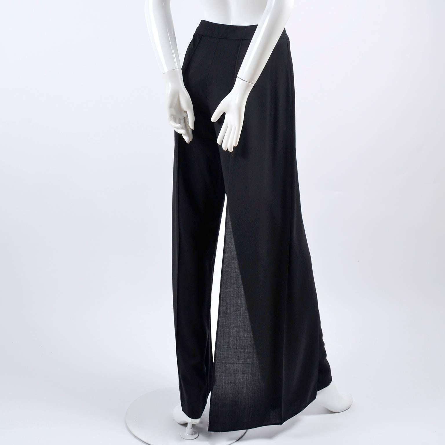 These black Chanel Pants are new with their original tags attached. The high waist pants are from spring 1999 and are made of black 100% ultra fine wool. The fly away panel on one of the sides give the appearance of palazzo style pants, as well as