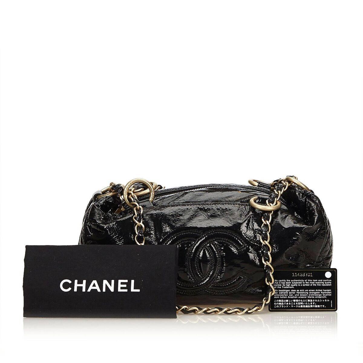 Product details:  Black patent leather shoulder bag by Chanel.  Dual chain shoulder straps.  Top zip closure.  Lined interior with inner zip and slide pockets.  Goldtone hardware.  Authenticity card and dust bag included.  14