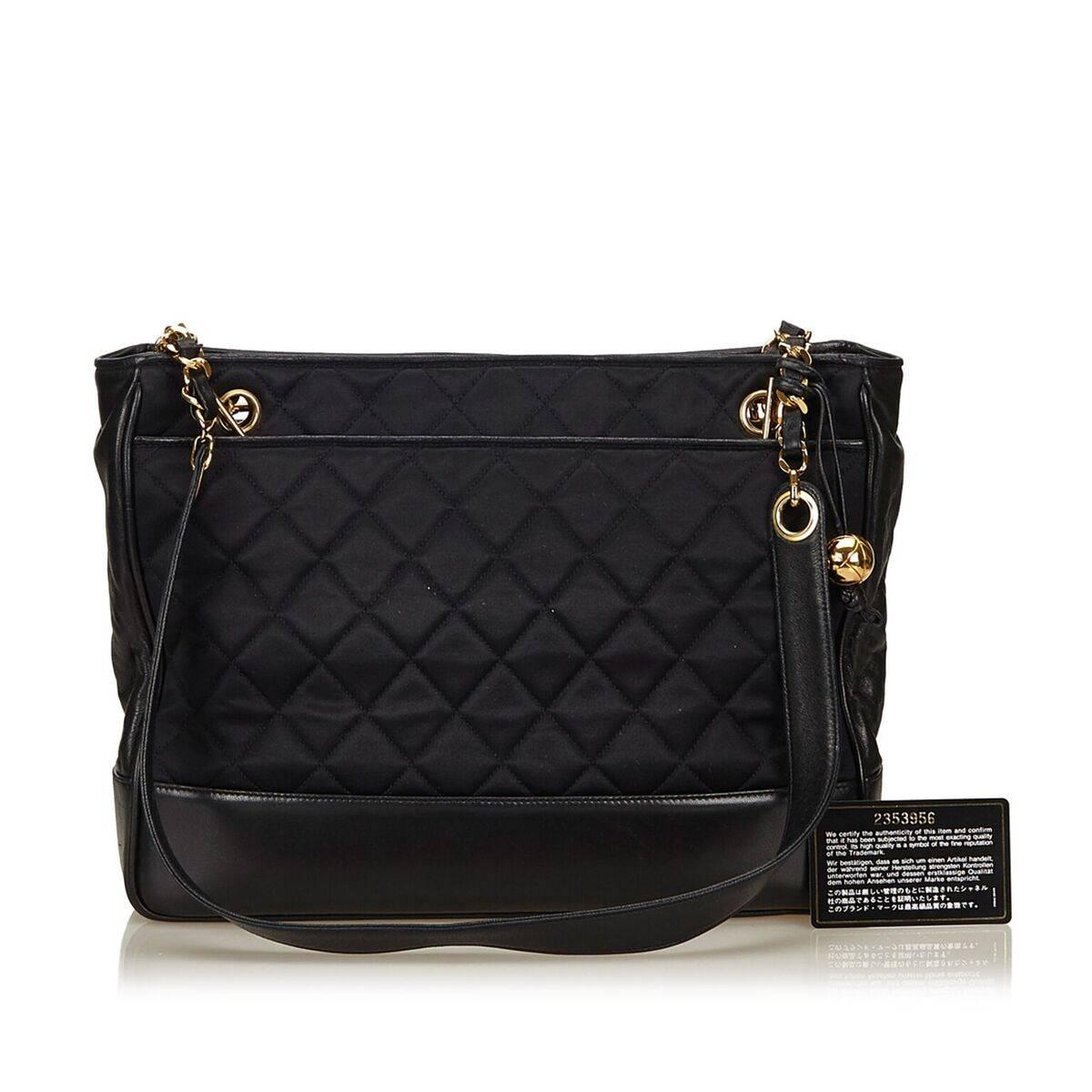 Product details:  Black quilted nylon shoulder bag by Chanel.  Trimmed with leather.  Top magnetic snap closure.  Leather lined interior with inner zip pocket.  Goldtone hardware.  Authenticity card included. 13
