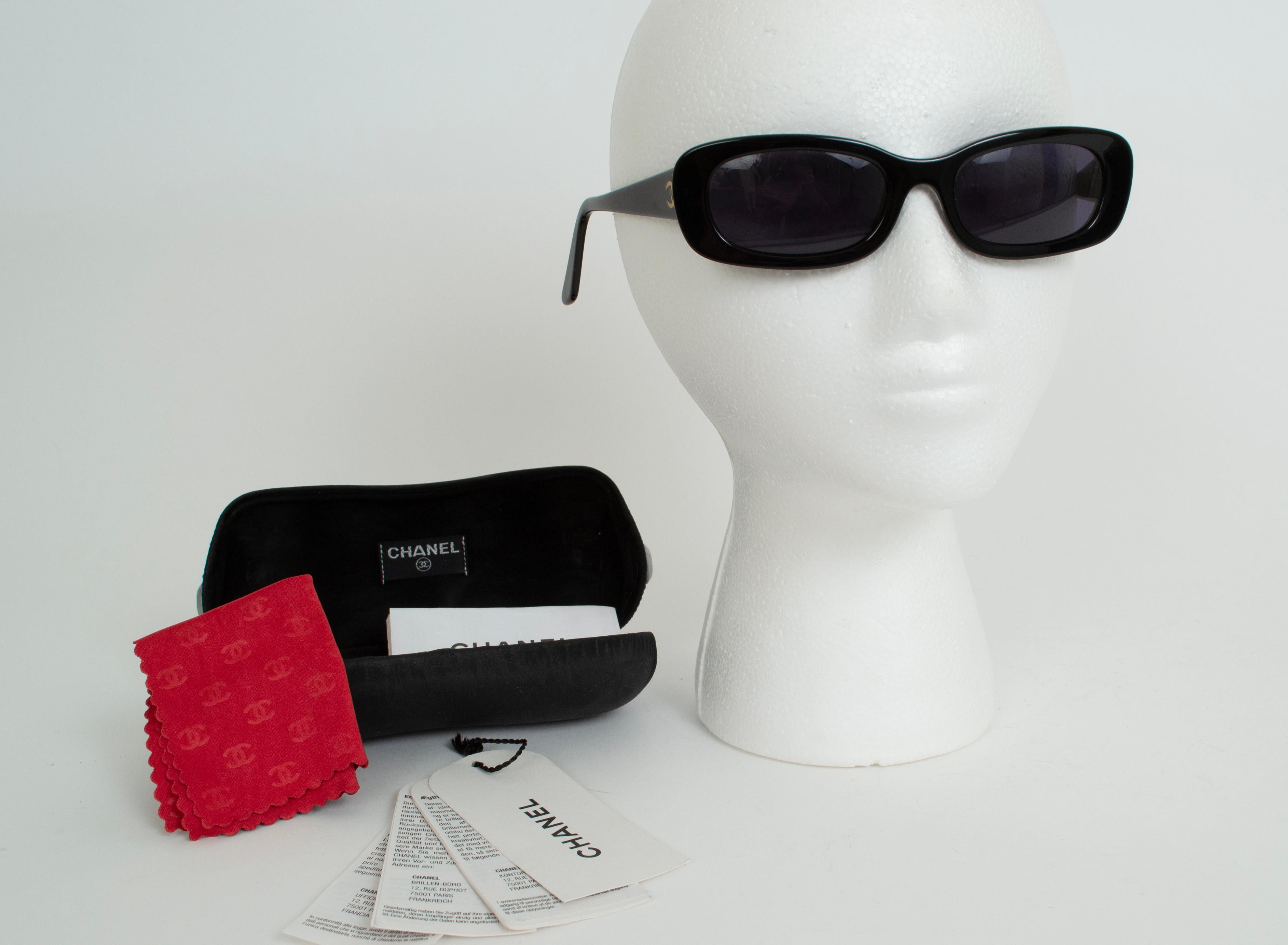 Estas gafas de sol Chanel hacen más chic la tradicional lente rectangular gracias al contraste de la montura más ancha en los laterales y las patillas. Lentes degradadas de color morado oscuro. Funda original, gamuza y etiquetas de autenticidad