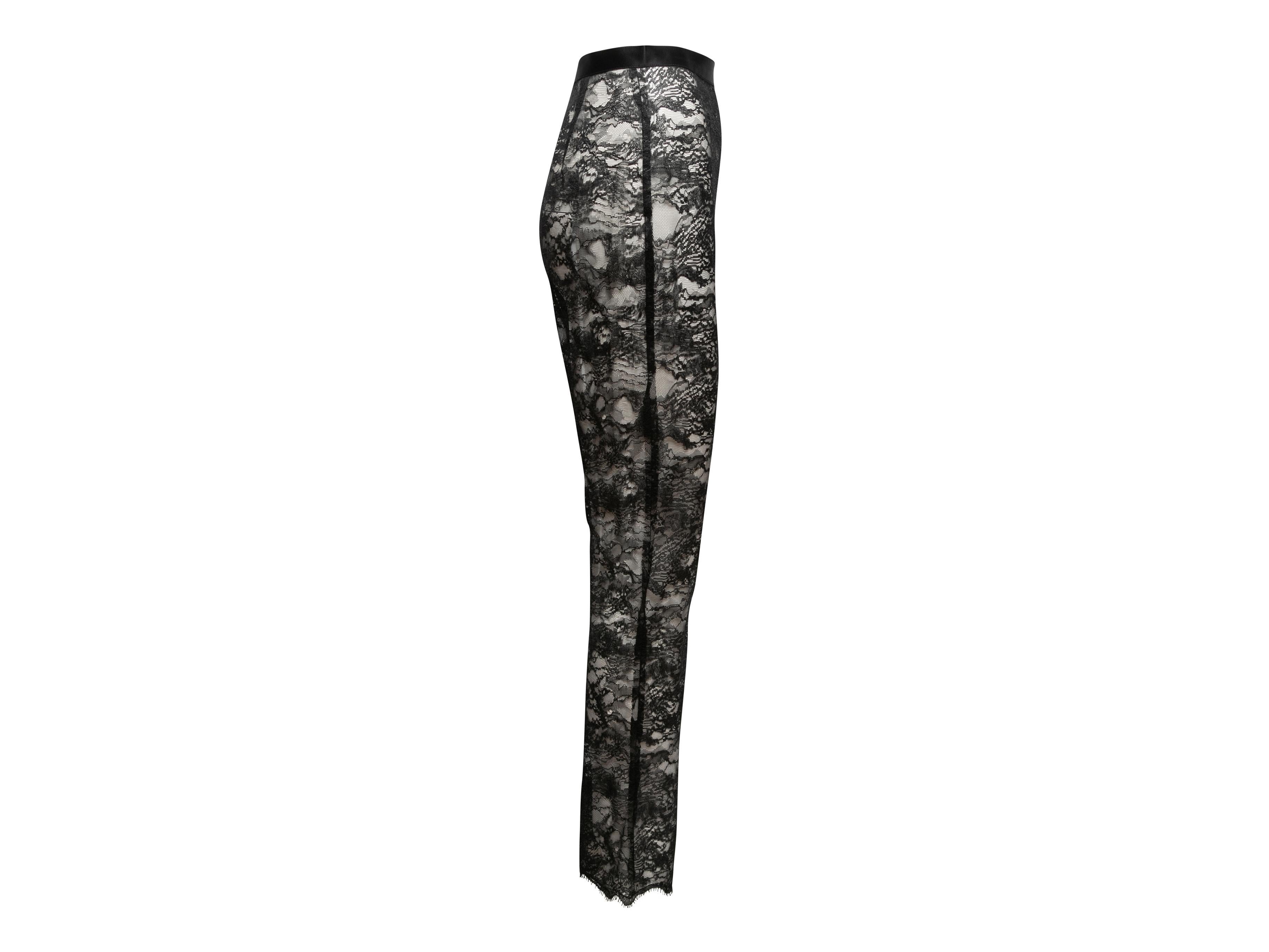 Black sheer high-rise lace pants by Chanel. Satin trim at waist. Zip closure at side. 25