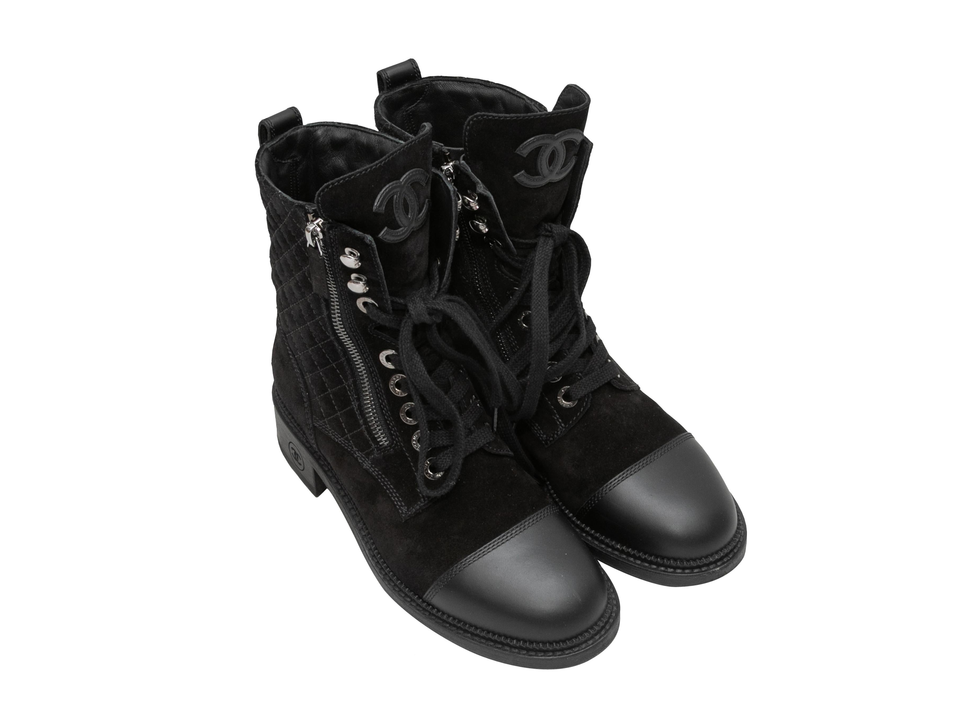 Black suede and leather quilted combat boots by Chanel. Cap-toe. Lace-up detailing at tops. Lug soles. Zip closures at tops. 6