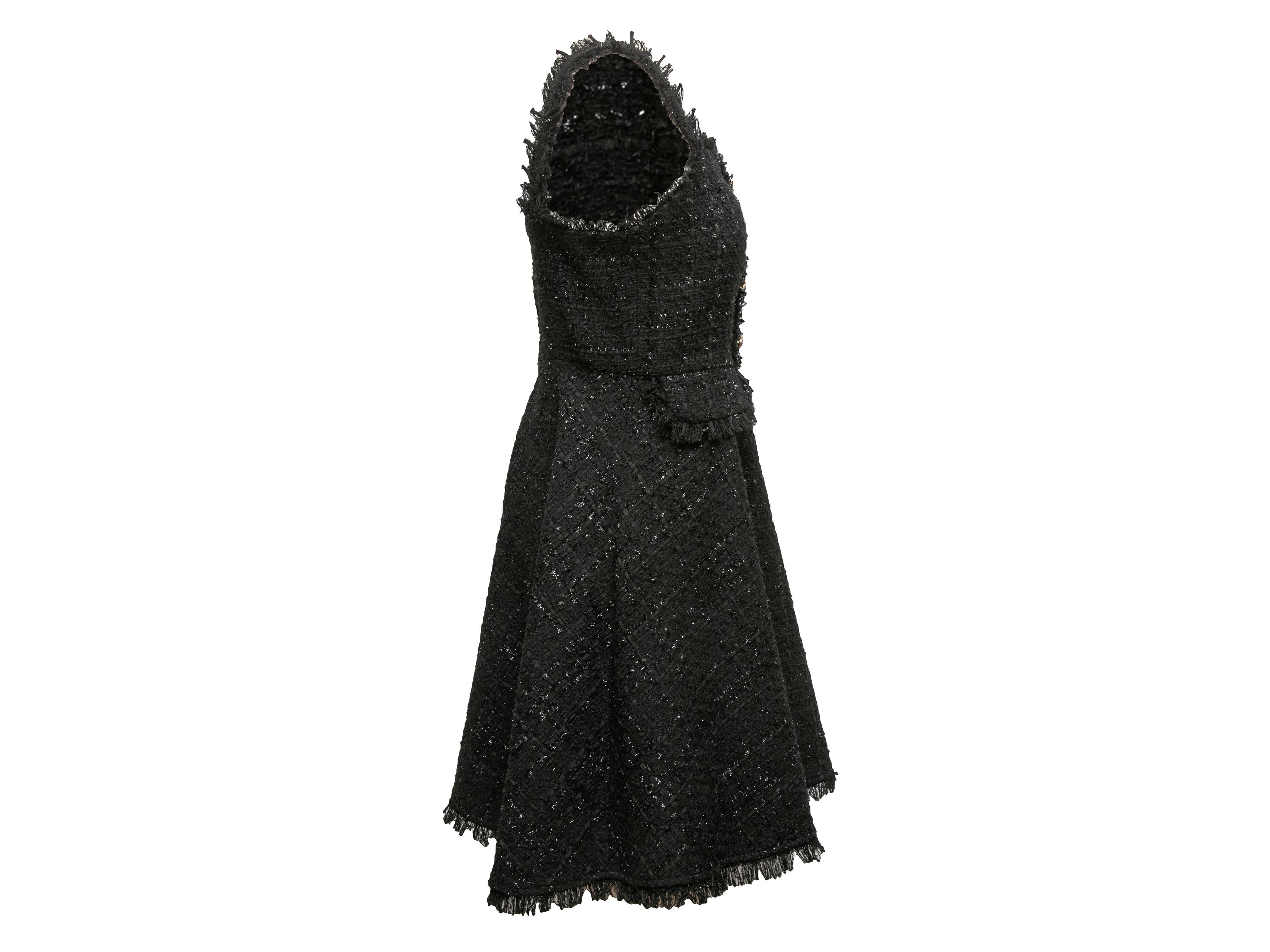 Black tweed sleeveless mini dress by Chanel. Sweetheart neckline. Button accents at front. Zip closure at center back. 34