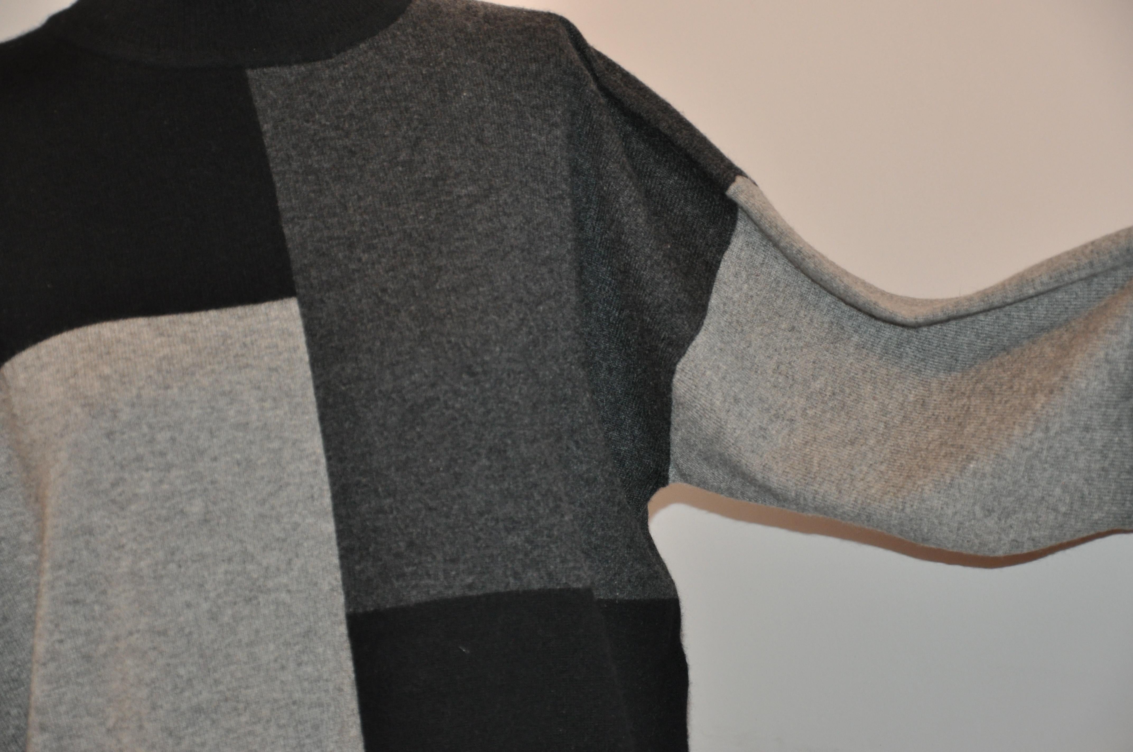 This Wonderfully soft 2-ply Cashmere Black, charcoal-gray and gray color-block abstract is detailed with a high-collar measuring 3 inches. This 2-ply cashmere tunic-length pullover measures 30 inches in back and 28 inches in front. The underarm