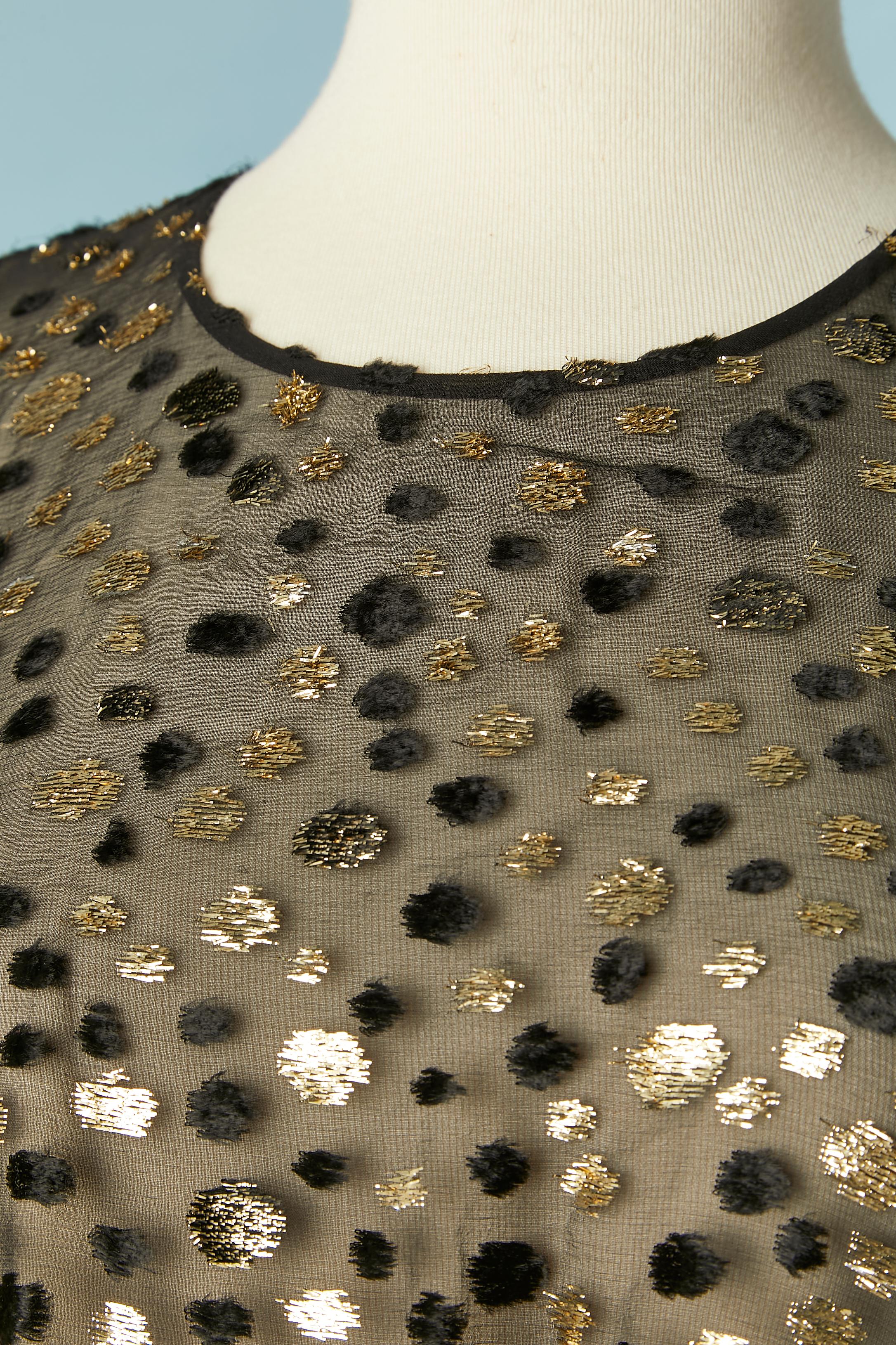 Vestido de cóctel de gasa negra con lunares de lúrex negros y dorados. Drapeado en el centro delantero. La parte superior del vestido es transparente.
Cremallera oculta y broche de presión en el lado izquierdo. Un botón y ojal en la parte superior