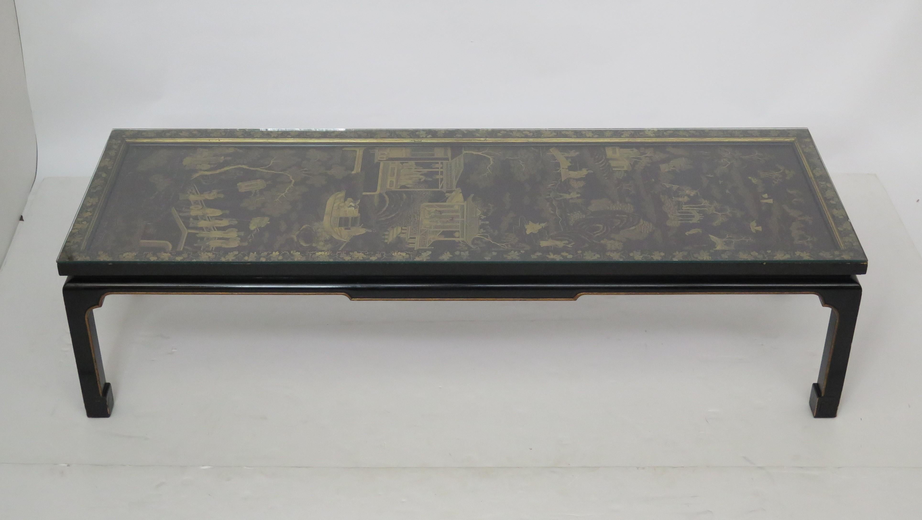 An elegant Chinese screen made into a coffee table. This table is black with gilt chinoiserie and all-over landscapes with figures and buildings with floral edge on straight leg base. Custom glass top.
19th century screen on 20th century base.
 