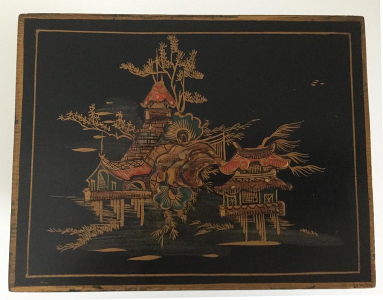 A black chinoiserie lacquered clock of small proportions, the rectangular case beautifully decorated in relief with garden scenes in shades of red, brown, green, black and gold highlights, on brass bun feet. The engraved brass dial has silver