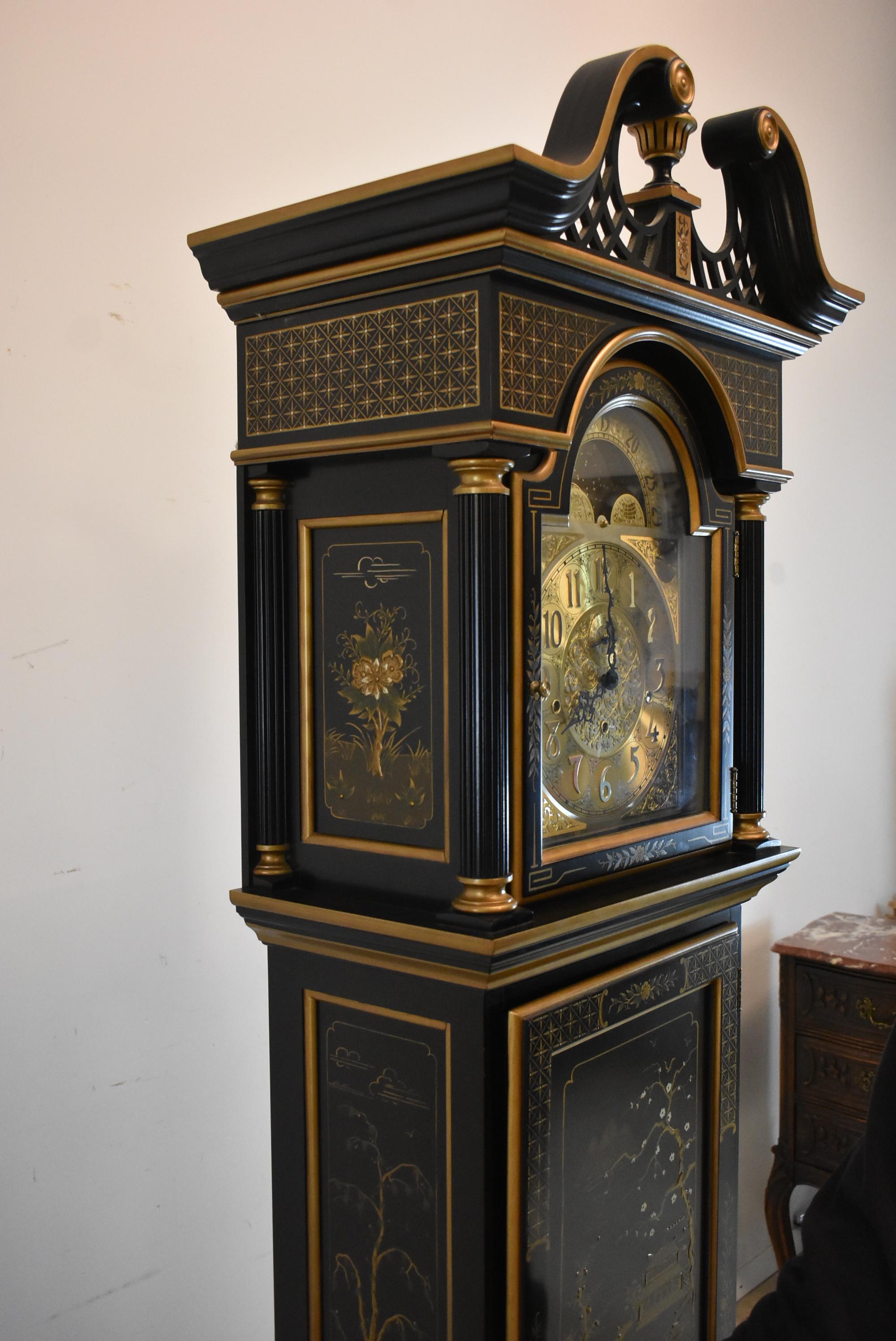 Beautifully decorated black chinoiserie grandfather clock by Sligh. Broken arch top with center finial all hand painted. Brass dial has moon phase. Multiple chime tone and silent setting. Model # 0996-1-BD. Running order.