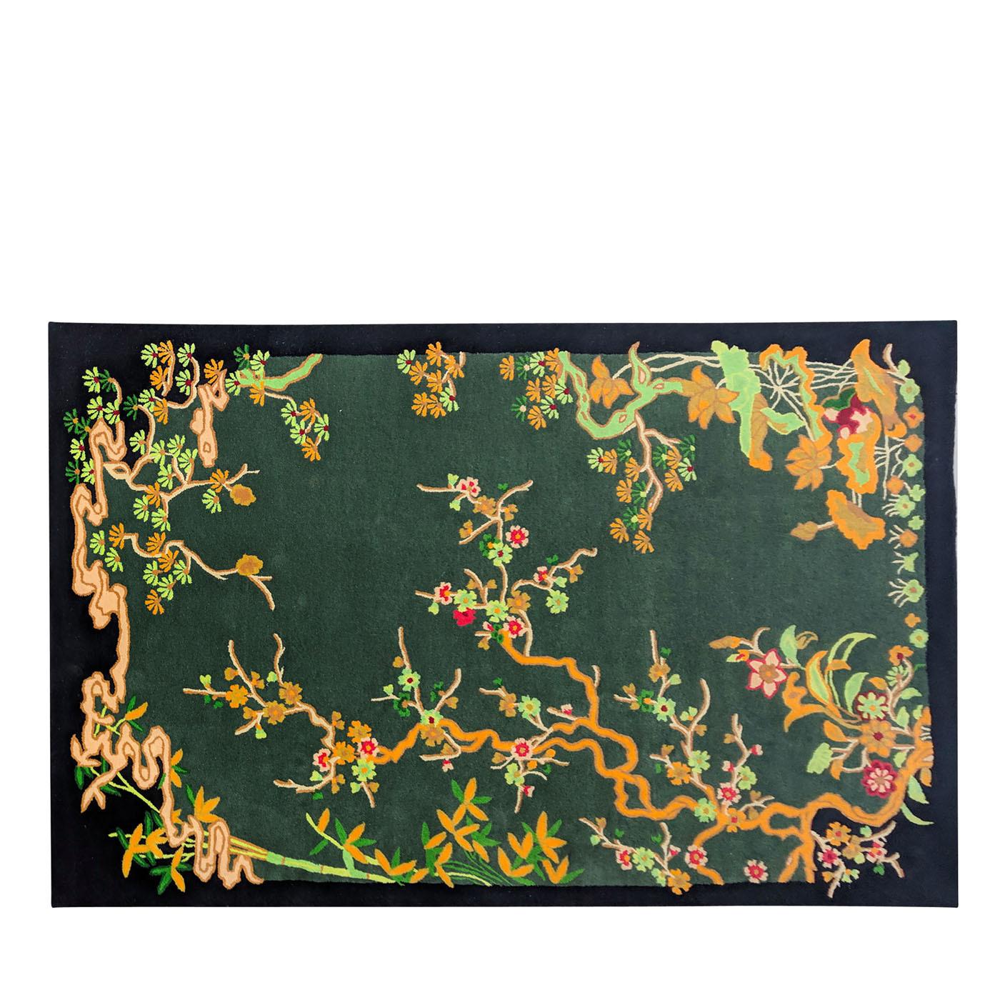 This hand-tufted rug exquisitely reinterprets a classic naturalistic theme with modern charm. Set on a green background, an array of stylized botanicals in deep, rich hues of orange, light green, and red frames the thick border in captivating