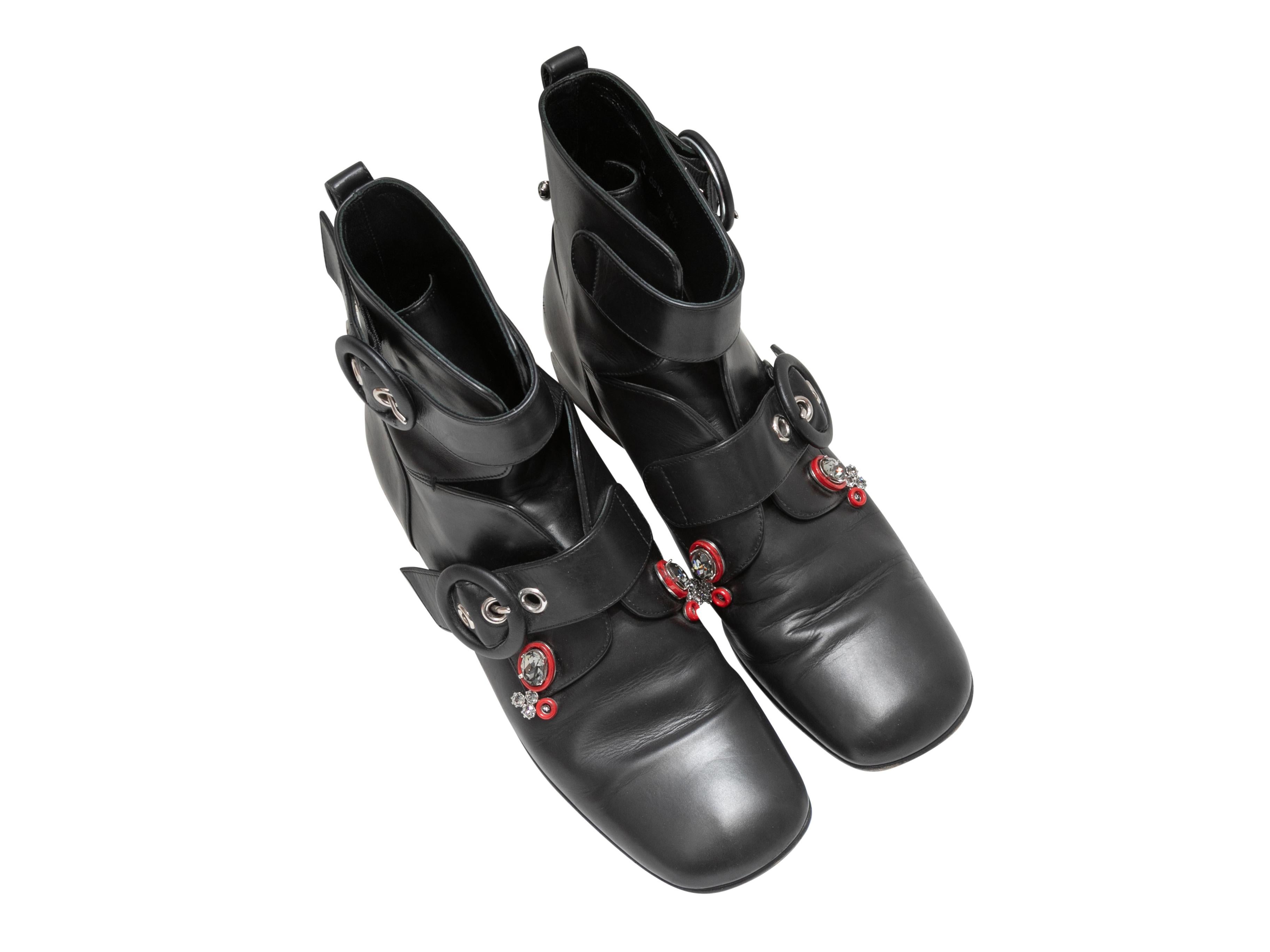 Black leather crystal-embellished cutout buckle ankle boots by Christian Dior. Block heels. Buckle closures at sides. 6