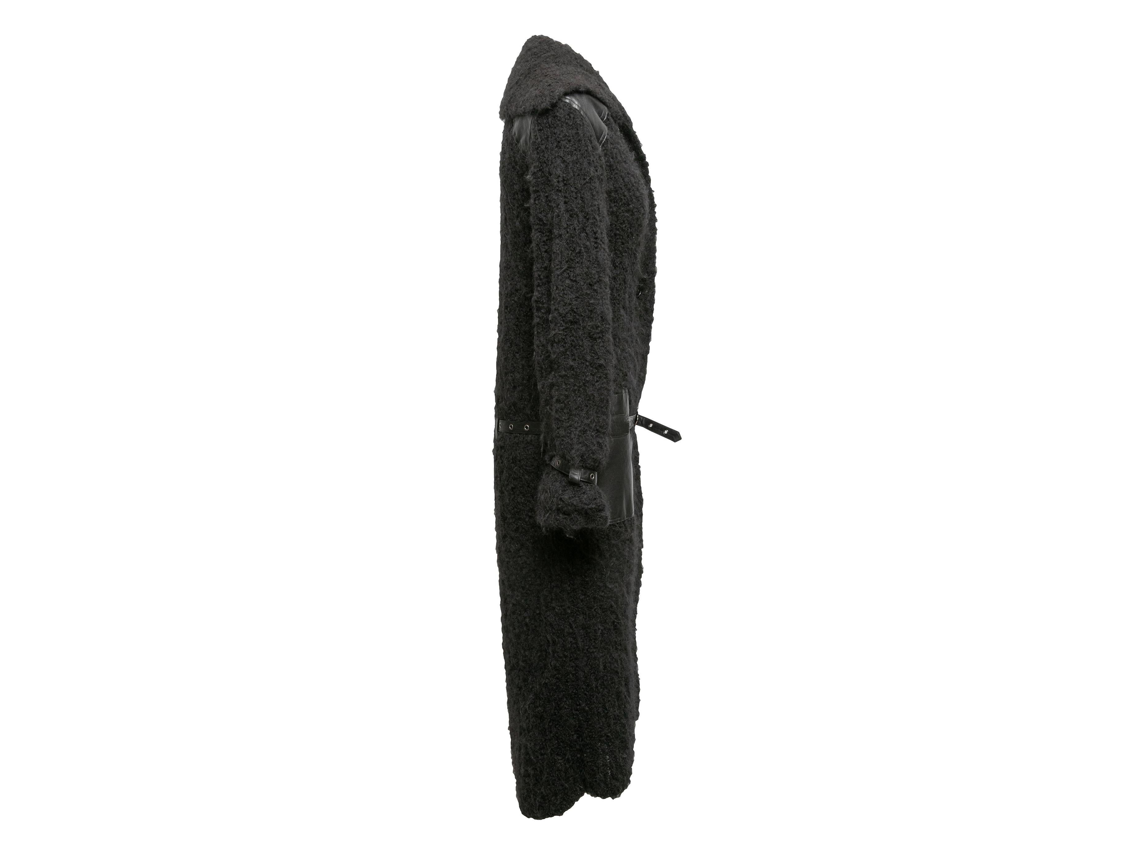 Cappotto lungo con cintura in lana nera e misto alpaca di Christian Dior. Rivestimento in pelle su tutta la superficie. Doppie tasche sui fianchi. Chiusura con bottoni sul davanti. Busto 34
