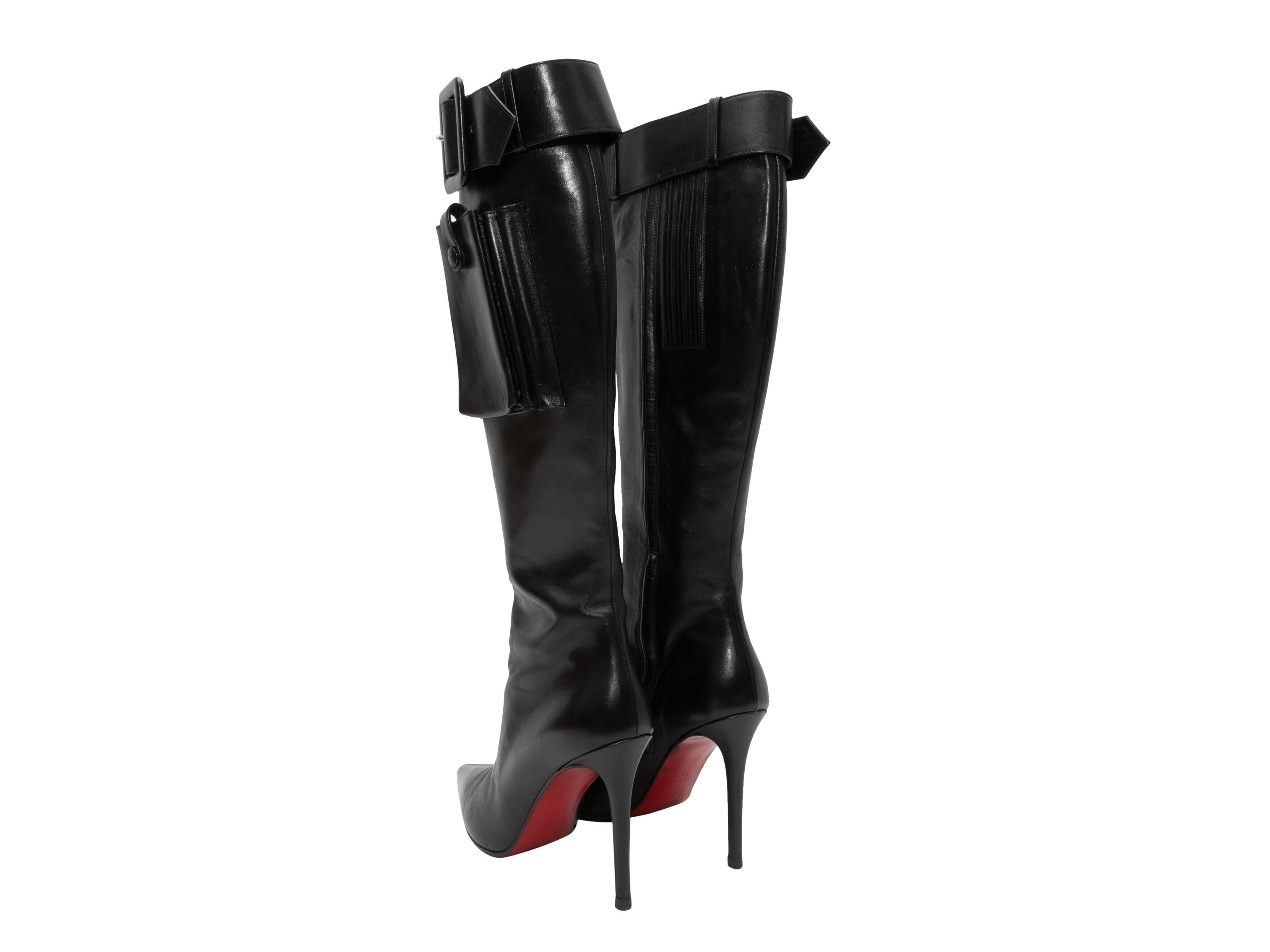 Black leather knee-high pointed-toe cargo pocket boots by Christian Louboutin. Buckle accents at tops. 15