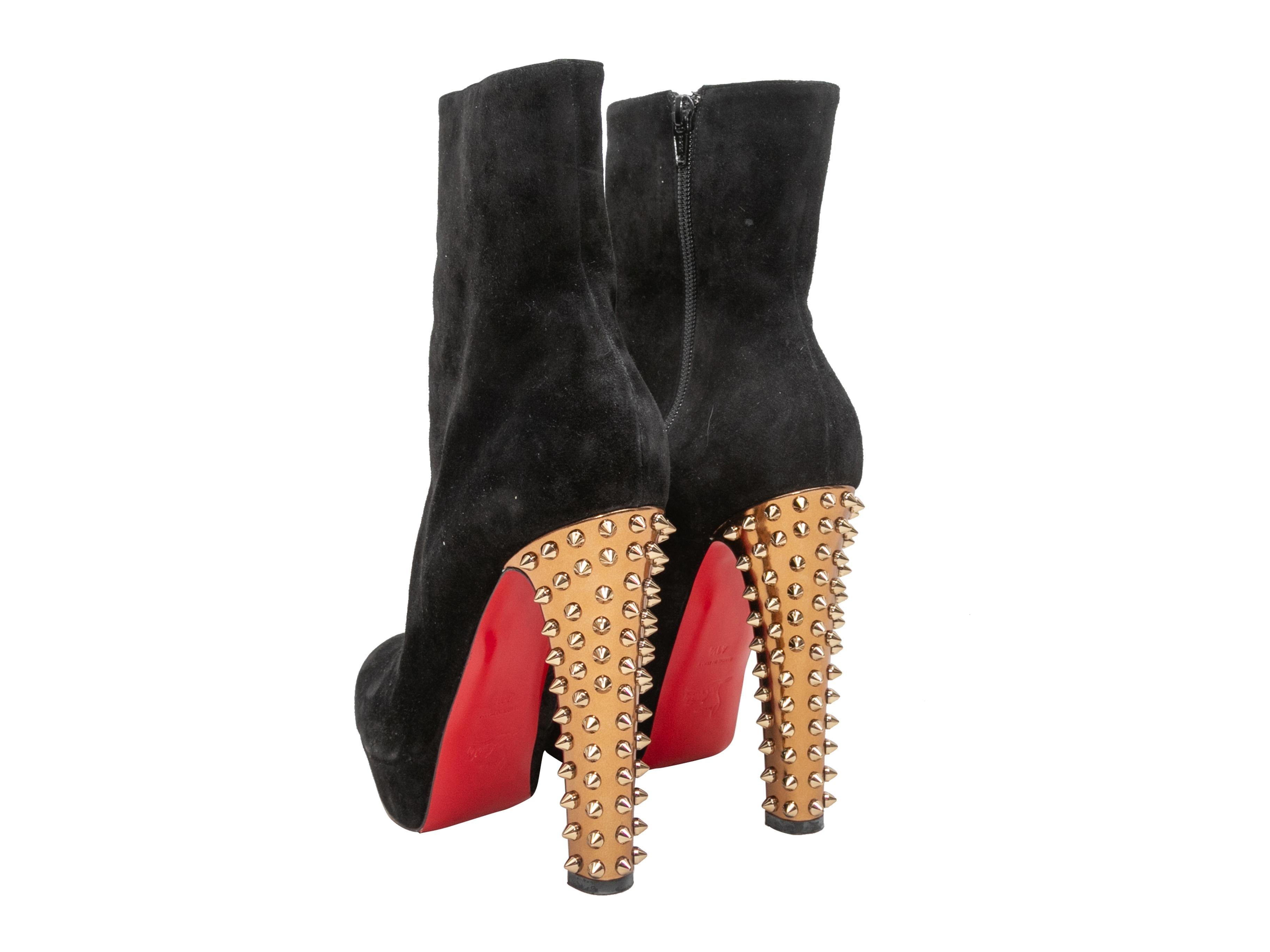 Black suede platform ankle boots by Christian Louboutin. Gold spike studded heels. Zip closures at inner sides. 1