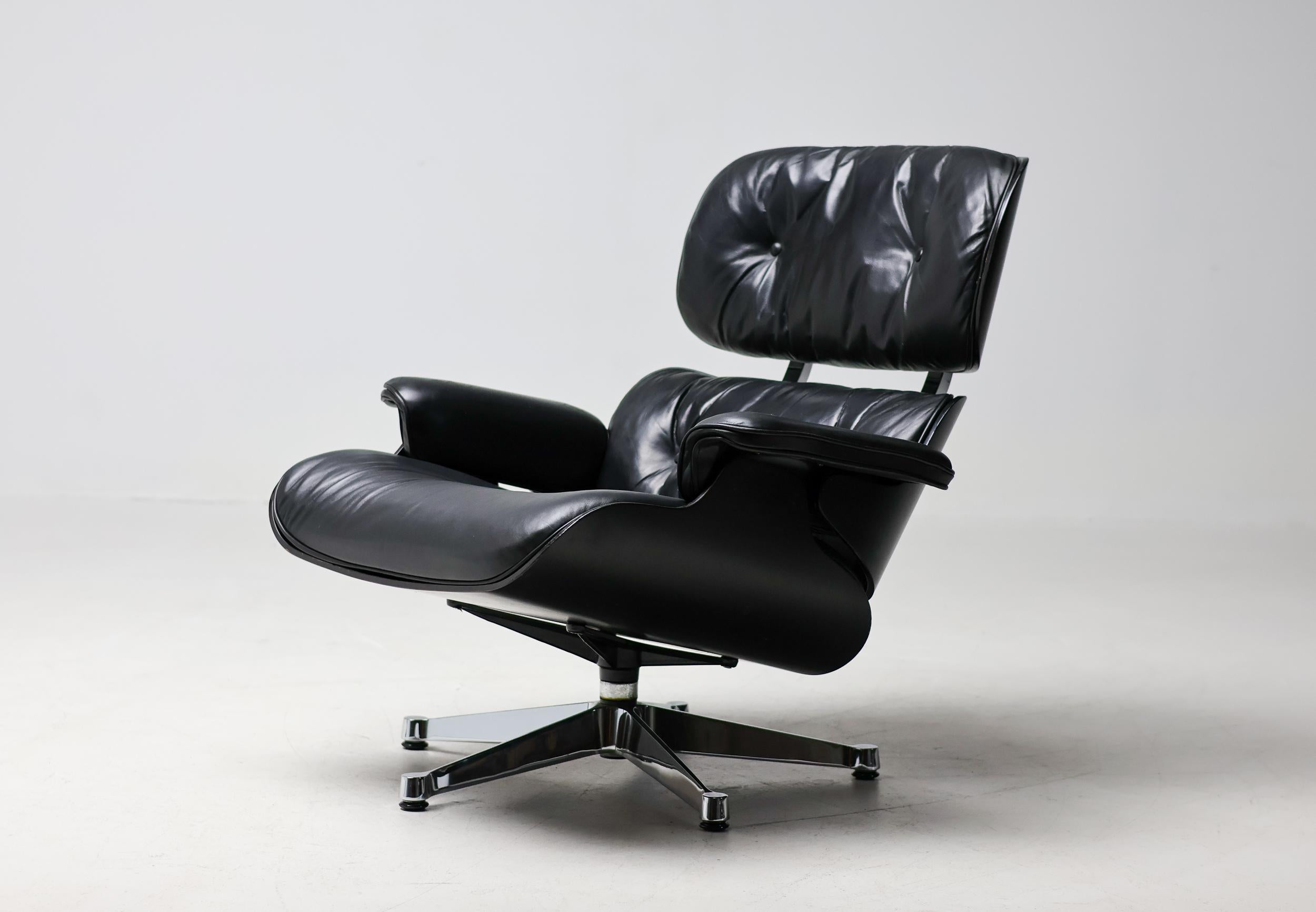 Silla Lounge 670 diseñada por Charles and Ray Eames para Herman Miller, con carcasa de madera contrachapada lacada en negro y tapicería de cuero negro. Este ejemplo con base y herrajes de aluminio cromado se fabricó en 1979, especialmente para el