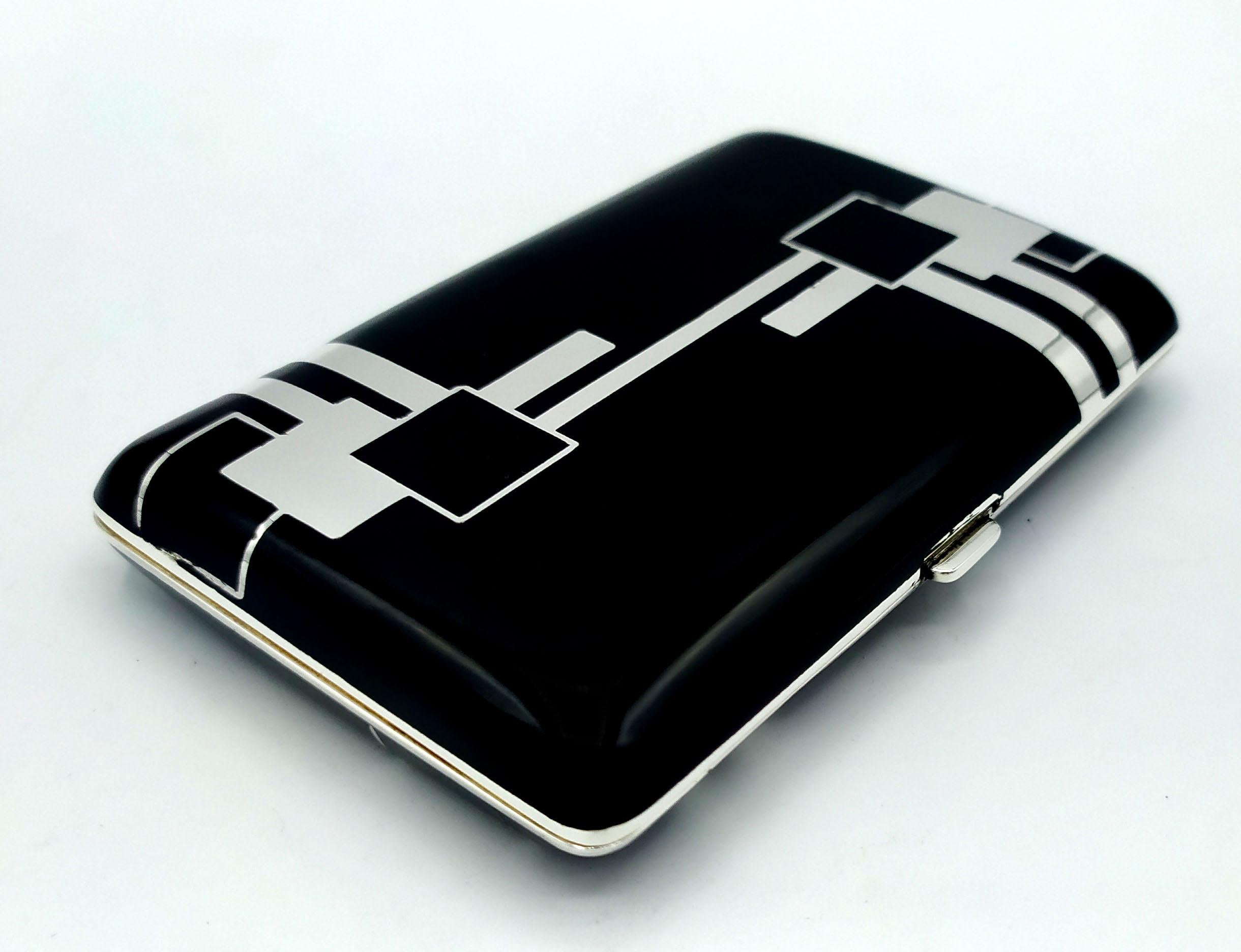 Cigarette case for handbag in 925/1000 sterling silver with black fired enamel. Opening with spring button.. Measure cm. 6.3 x 9.7 x 1.5. Weight gr.210. Created in the Art Deco style for Cartier USA in the 1980s, inspired by designs by Louis Cartier