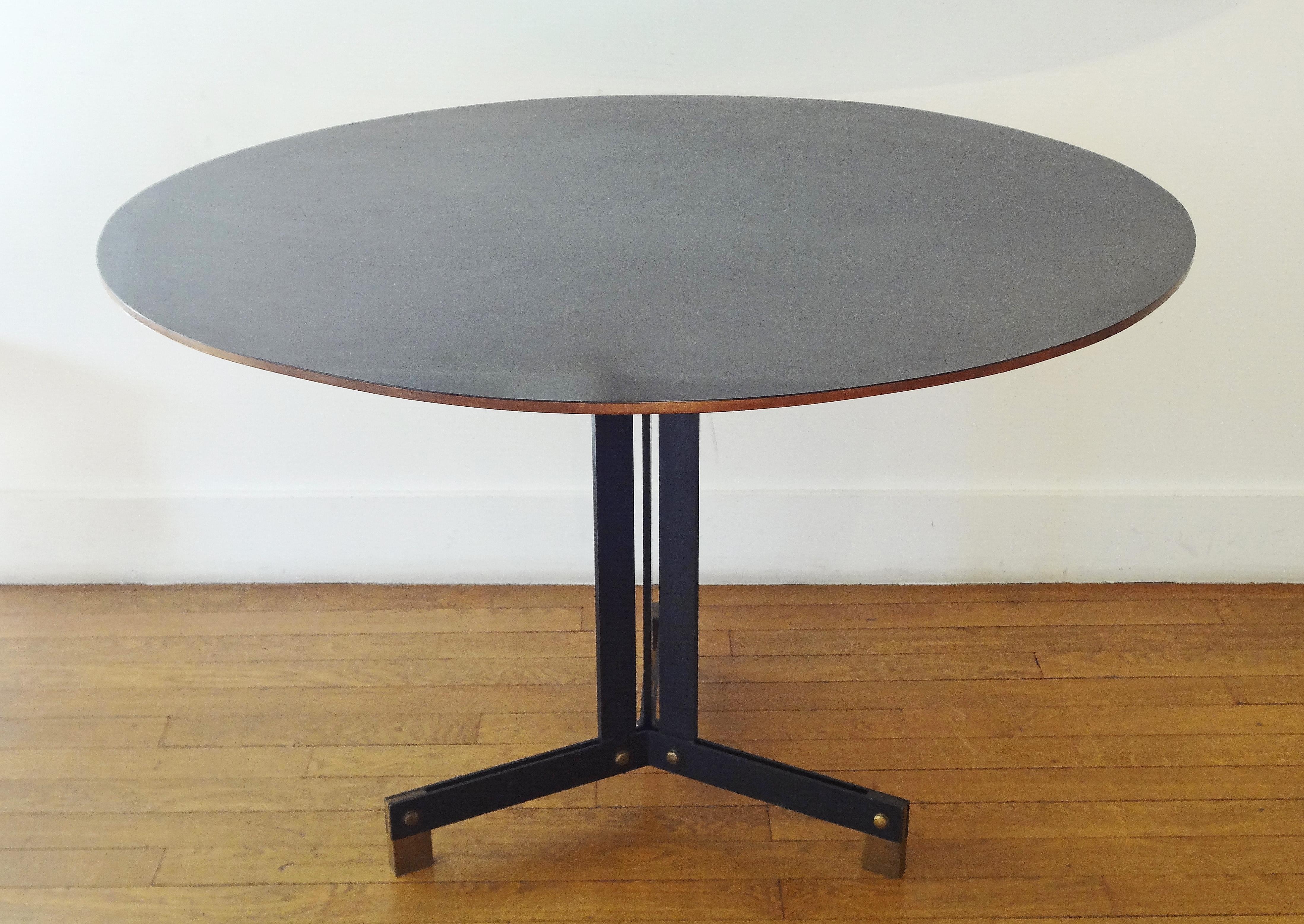 Ignazio Gardella, Italie, 1960.
Black lacquered circular table.
Wood top, tripod black patinated metal base with straight feet, gilt brass sabots.
Ancient Edition Azucena.
Measures: Base width 64 cm. 
 