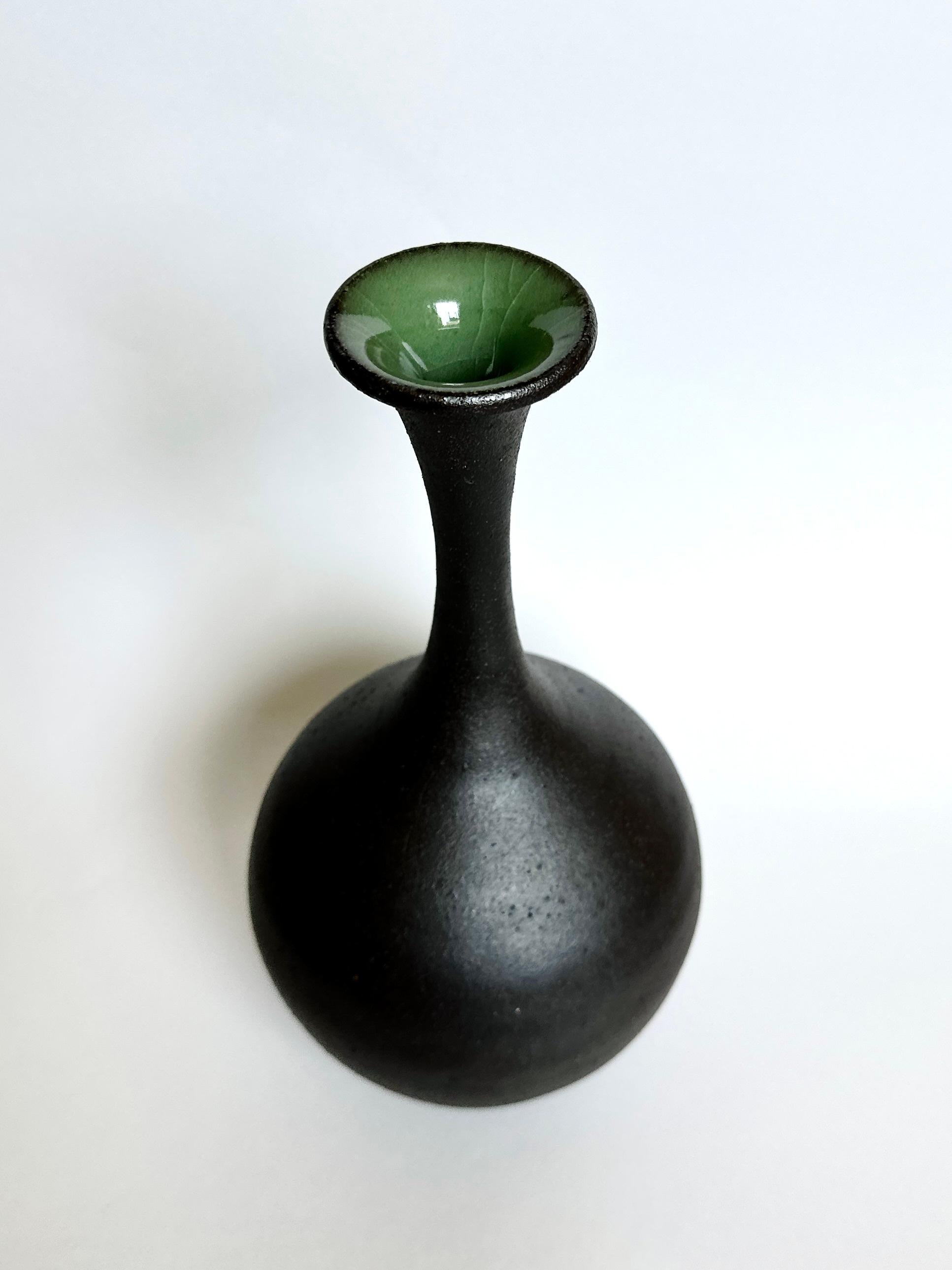 Tall wheel-thrown, hand-built and carved bottleneck vessel made with a rich and beautiful black clay with only the mouth glazed in a green celadon. A personal favorite, in part because it's rather miraculous it made it through the firings with such