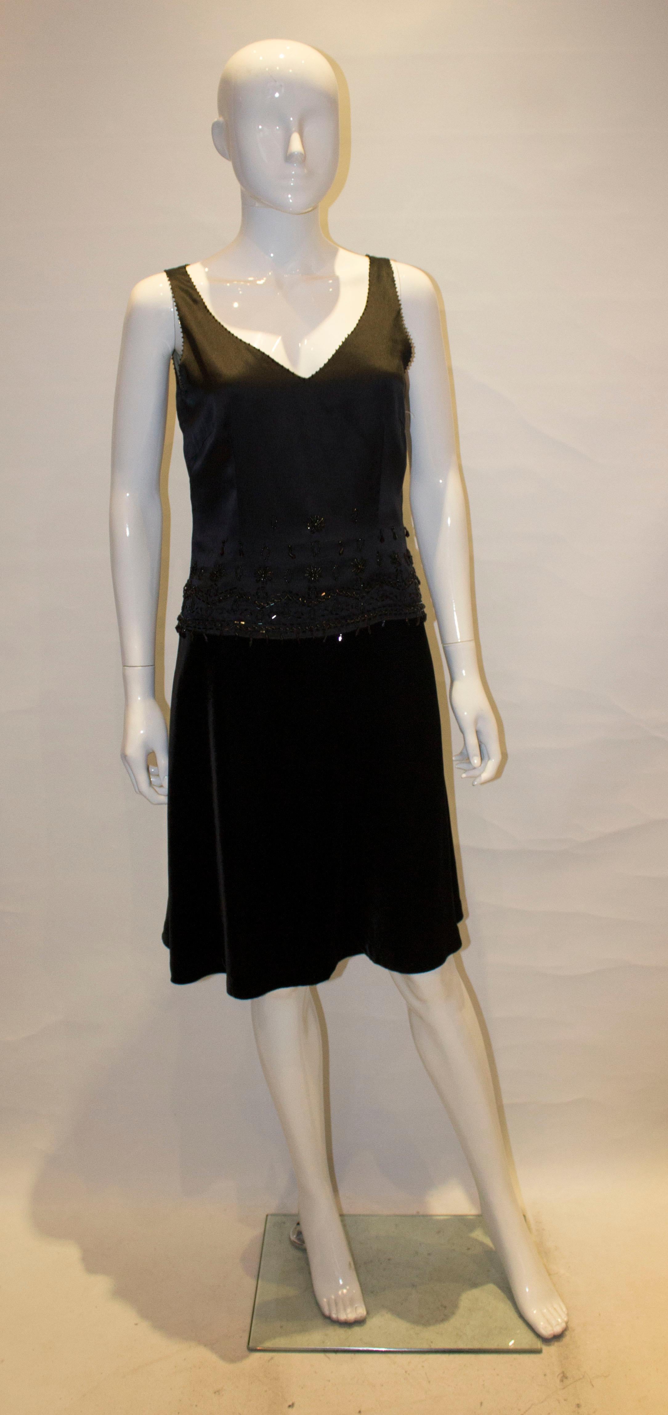 A pretty and easy to wear cocktail dress by Birger and Mikkelsen. The dress has a silk upper part and velvet skirt. There is some decorative bead work. The dress is fully lined and has a side zip opening.