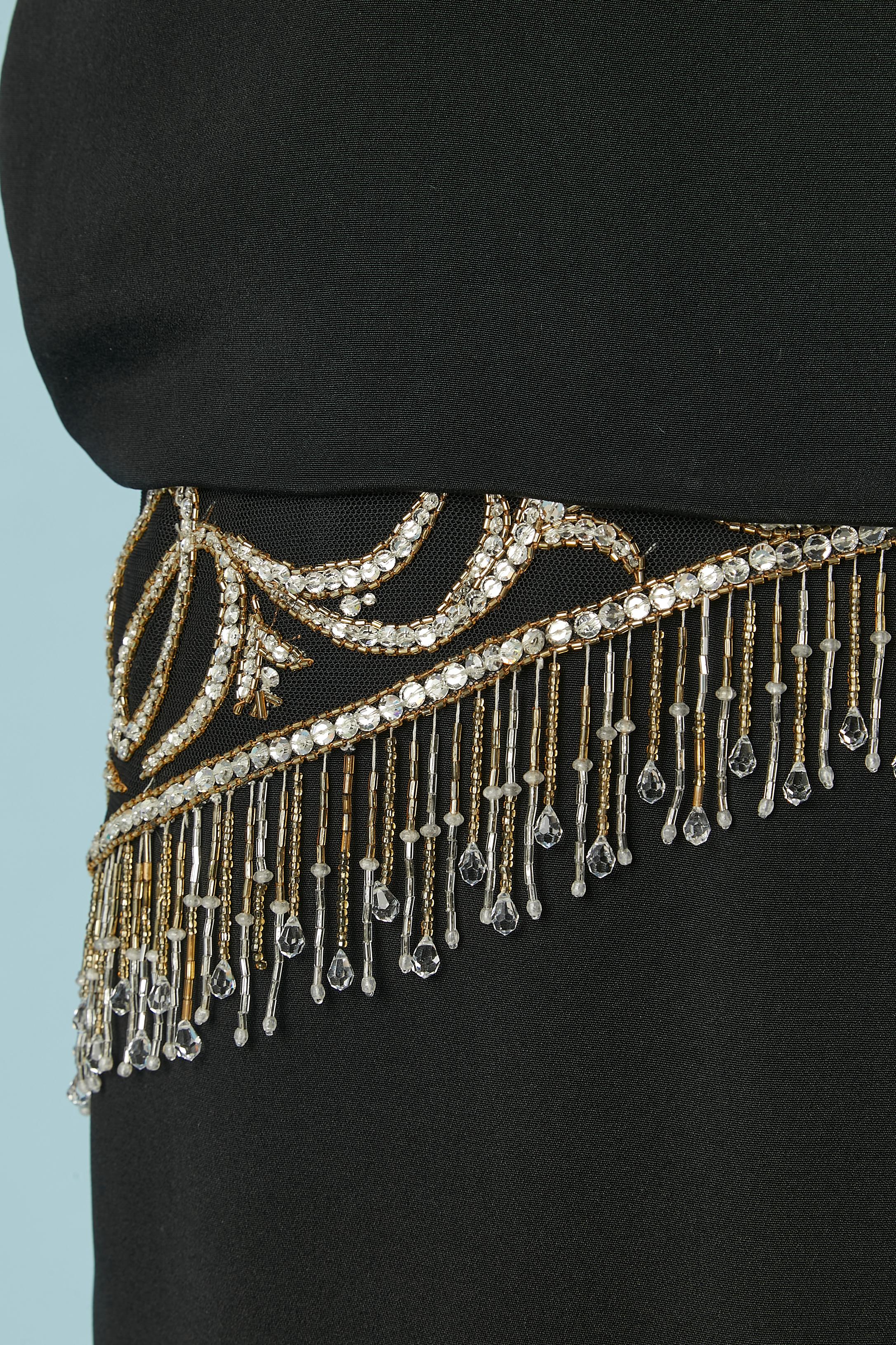 Schwarzes Rayon-Cocktailkleid mit Strass-Perlen Fransen embellishement um die Taille auf einem Tüll lag.  Unsichtbarer Reißverschluss in der Mitte des Rückens, Haken & Öse  und Druckknopf (um die Rückseite des perlenbesetzten Tülls zu halten)