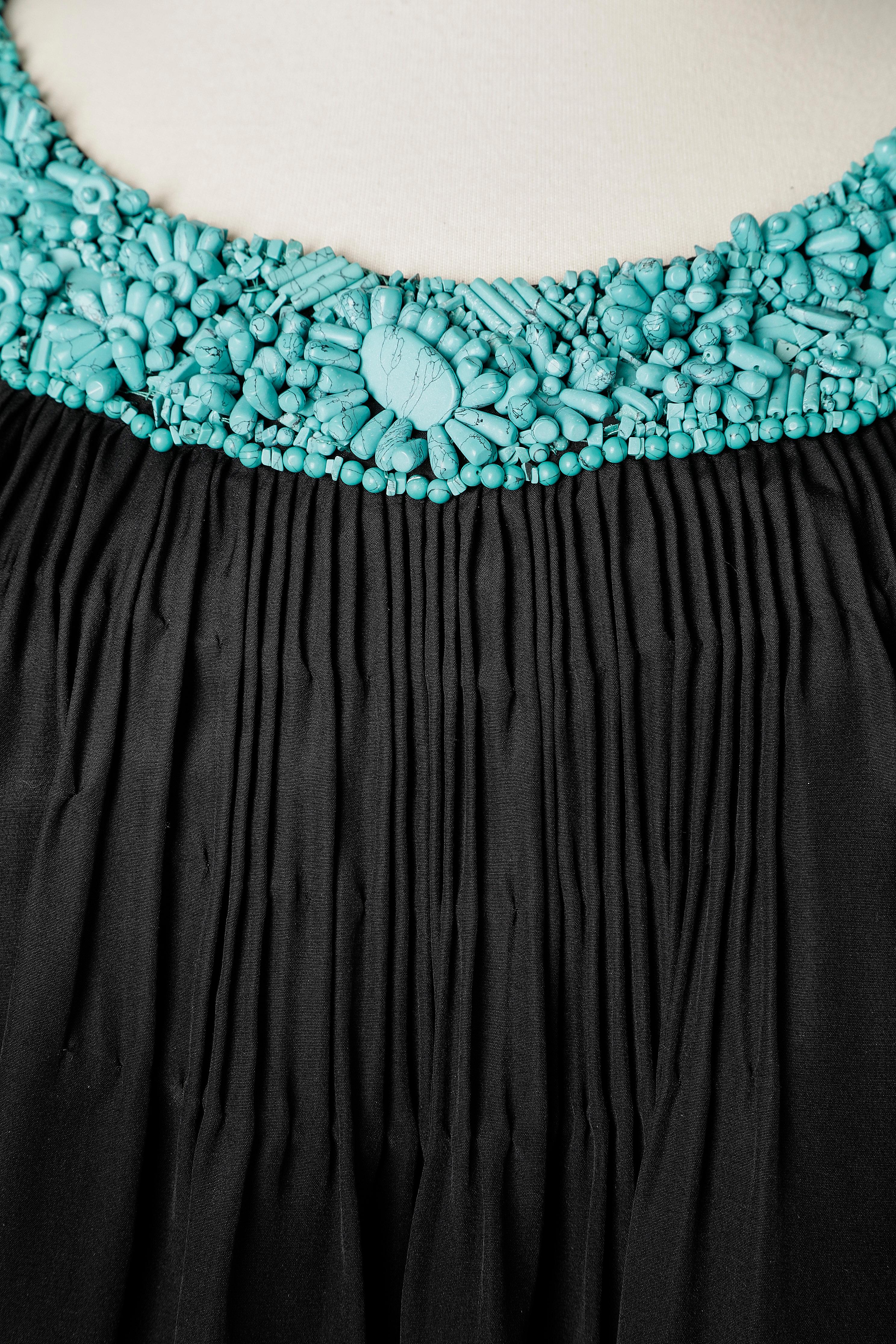 Black cocktail dress with turquoise beaded neckline.
SIZE 8 