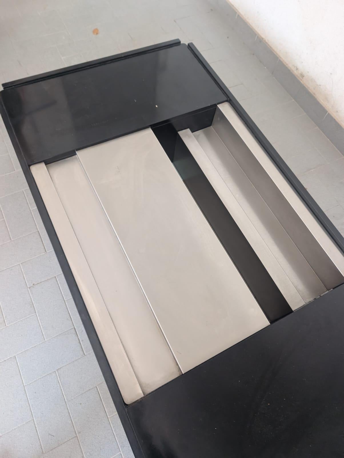 Dieser schwarze Couchtisch von Mario Sabot und Willy Rizzo aus den 1970er Jahren ist ein Beispiel für bemerkenswerte Handwerkskunst und zeitlose Eleganz. Aus Edelstahl und schwarz lackiertem Holz gefertigt, verbindet er mühelos Haltbarkeit mit Stil.