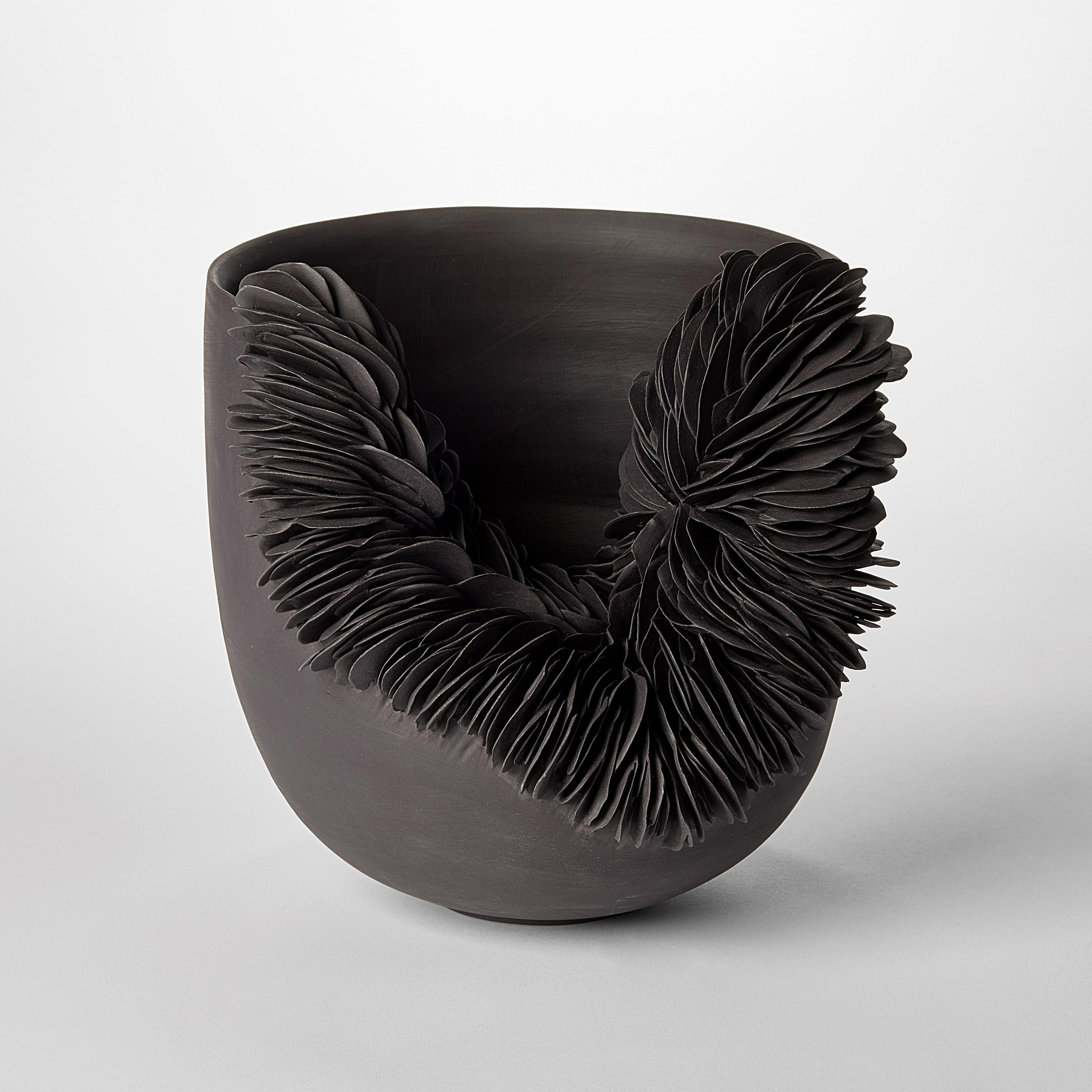 'Black Collapsed Bowl' is a unique porcelain sculpture by the British artist, Olivia Walker.

Walker works in porcelain to create pieces that explore ideas of growth and decay through the construction and layering of complex surfaces.

All of her