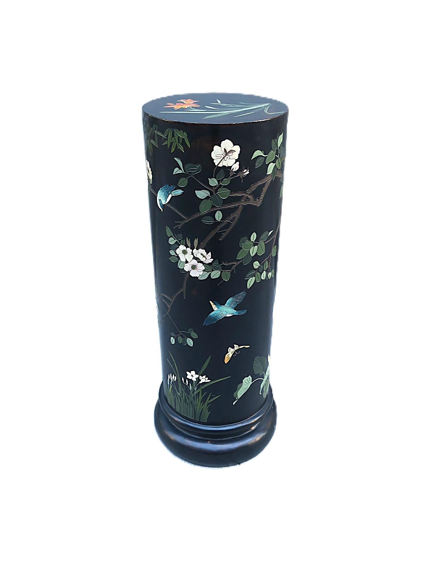 A black ebonized column pedestal stand (plant stand) with birds, flowers and butterflies, in the Chinoiserie design style, circa late-20th century. Column is cylindrical with a wood base and composition/resin-like finish; black ground hue, covered