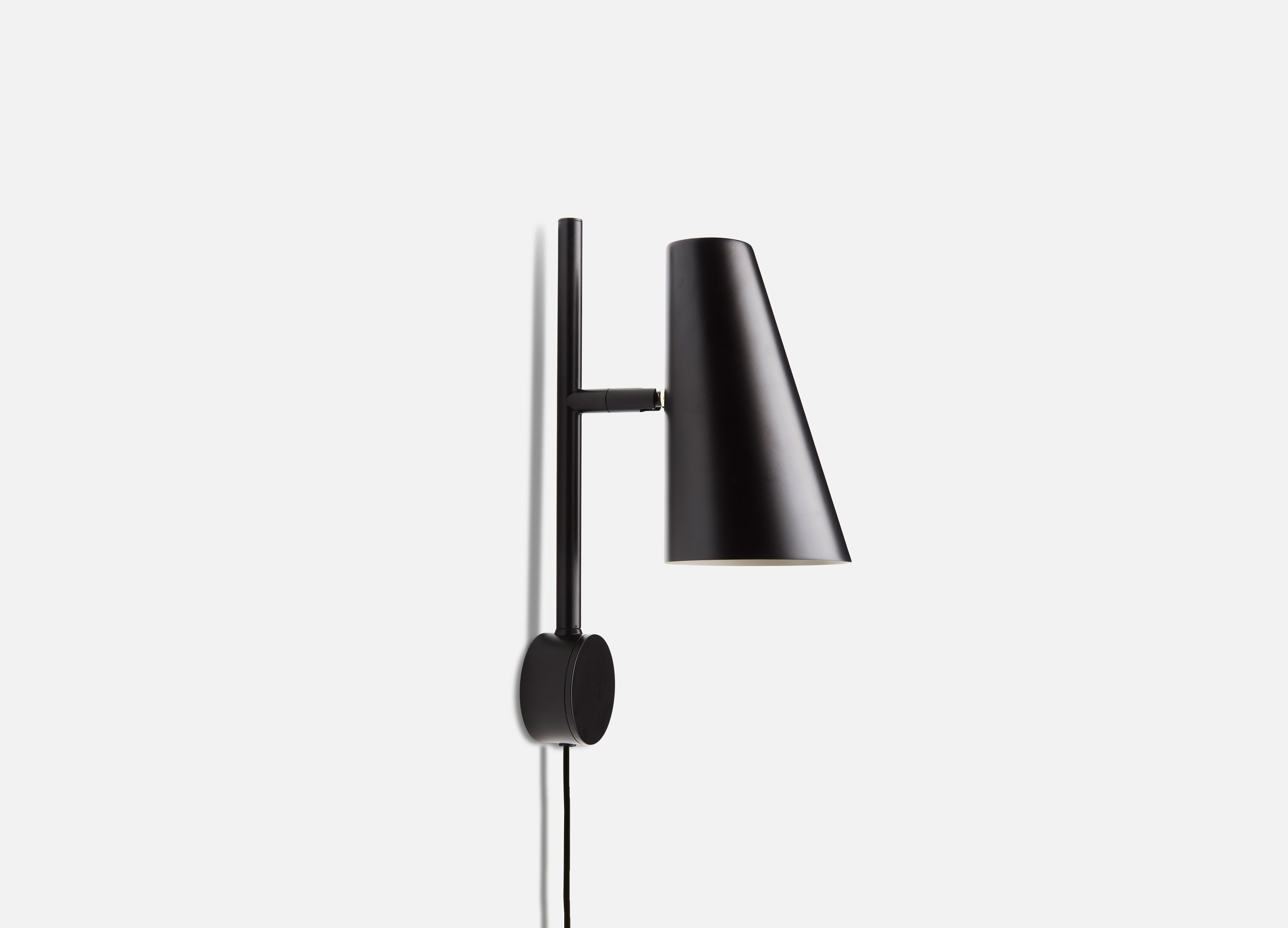 Black Cono wall lamp by Benny Frandsen.
Materials: Metal.
Dimensions: D 11 x W 17 x H 33.3 cm.
Available in black or satin.

Benny Frandsen is a renowned and experienced danish designer and founder of the lighting company frandsen, which has