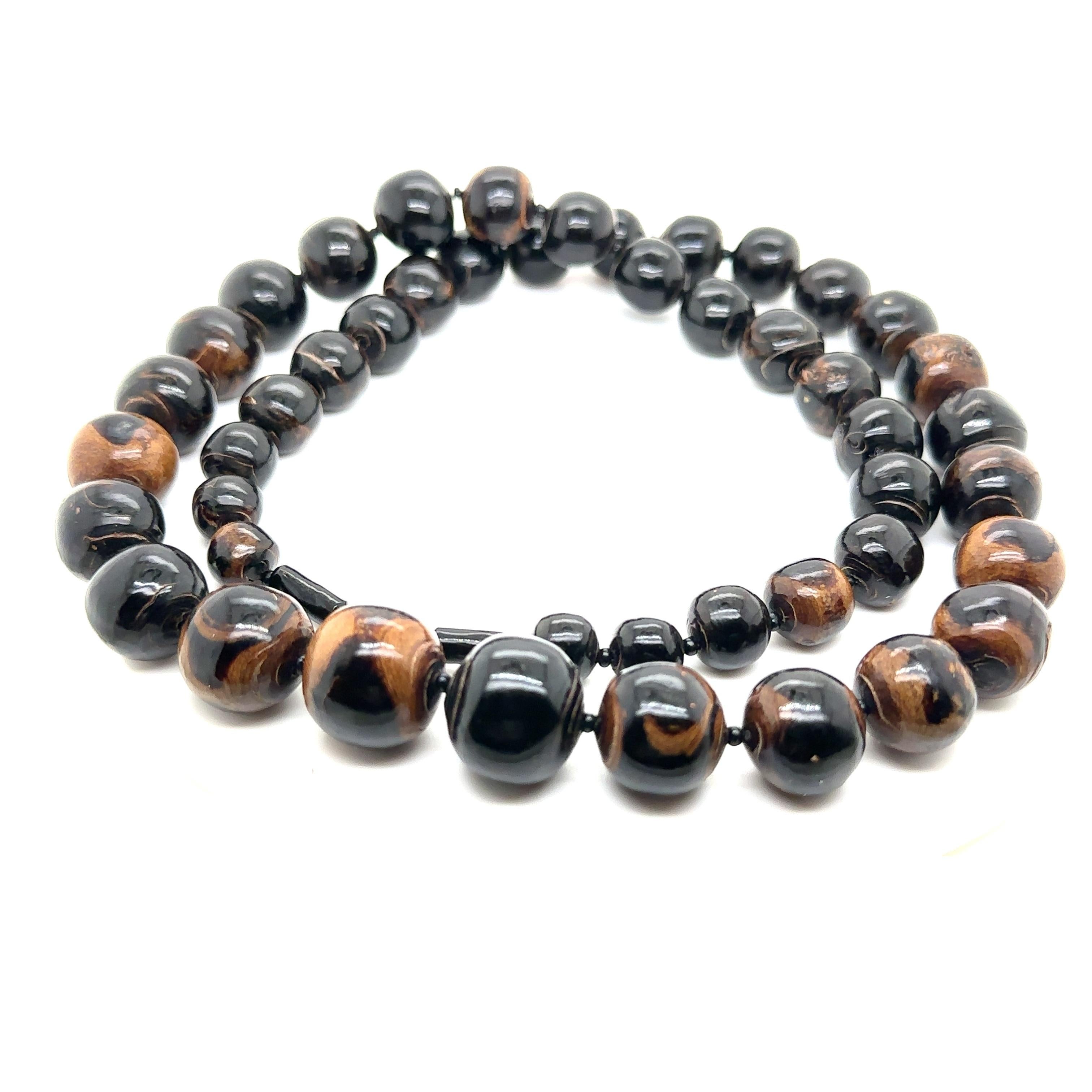 Fantastic and rare natural black coral graduated bead necklace. The length is 26 ½ inches and the beads range from 9MM to 16.55MM. The round beads which show a variegated vivid black and gold color are very beautiful and clean in texture. 

This