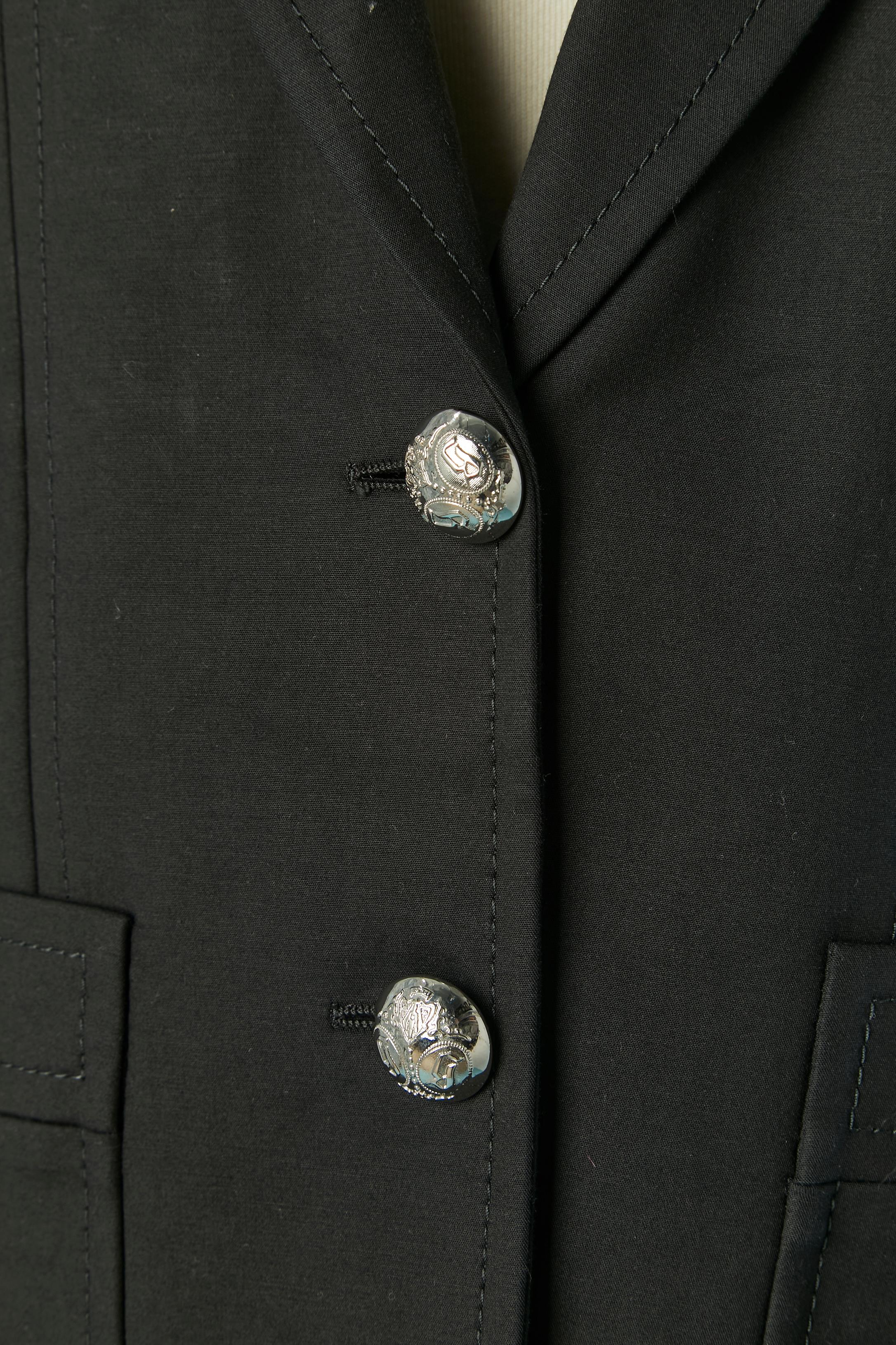 Blazer in cotone nero con chiusura a bottoni in metallo argentato con marchio sul centro davanti e sui polsini. Composizione del tessuto principale: 95% cotone, 5% elastan. 
Spallina sottile. Tasca su entrambi i lati. Spaccato sulla parte centrale