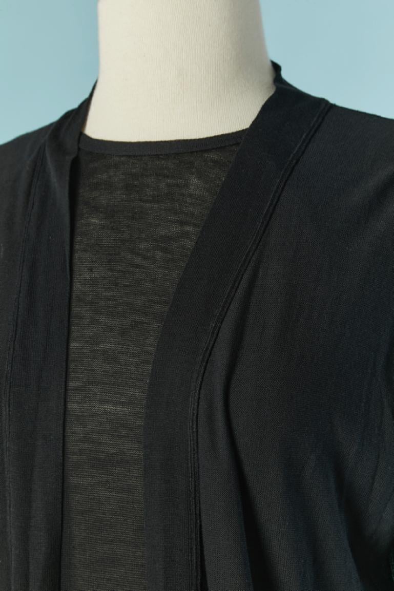 Black cotton jersey double vest  and backless sweater. The vest is going on the top of the long sleeve backless sweater (which is tied behind the back and with 2 bows) and both pieces are attached on the bottom. One pocket on the vest on the right