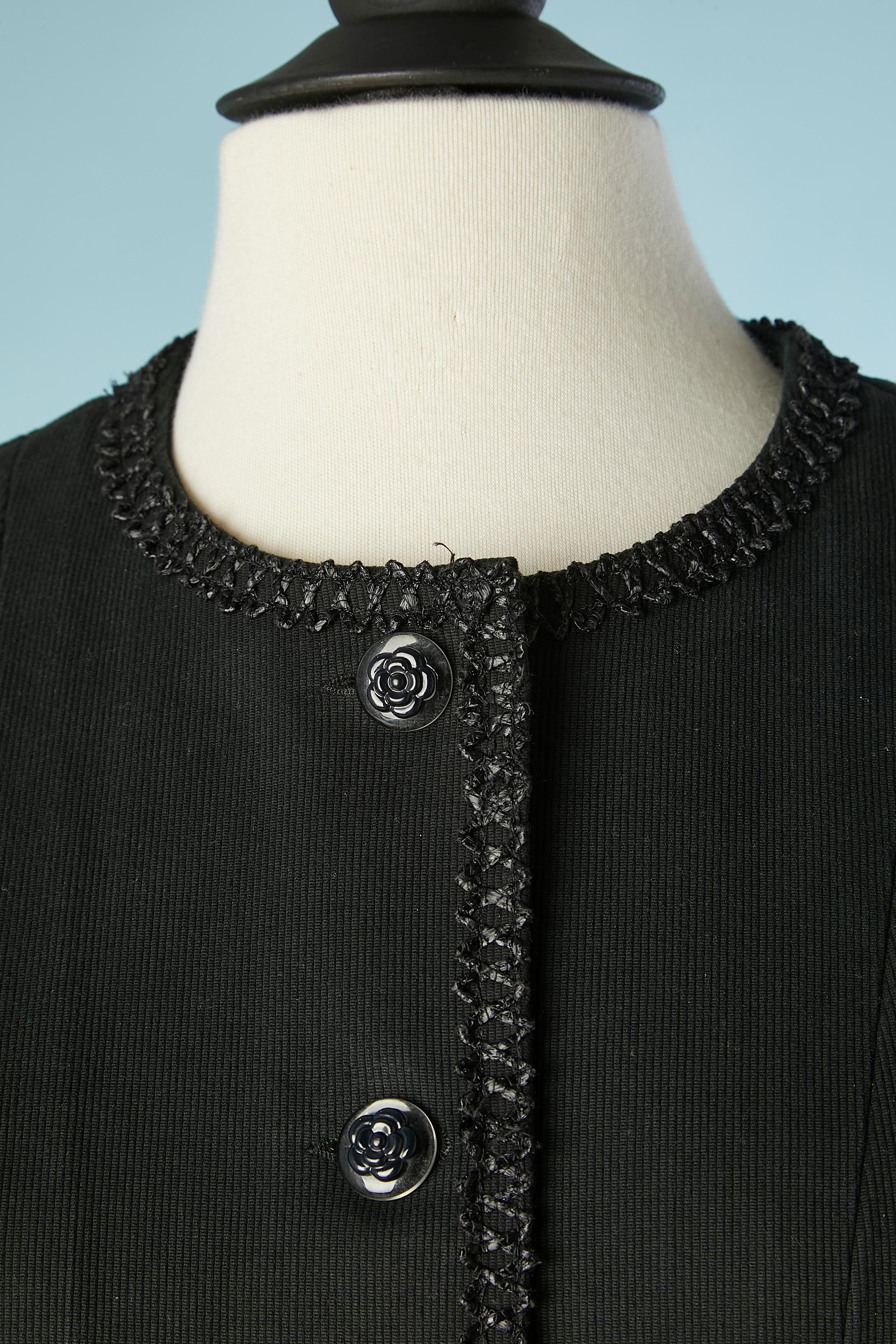 Combinaison jupe en coton noir avec bord en raphia et boutons camélia. Pas de doublure mais un passepoil à l'intérieur.
TAILLE M