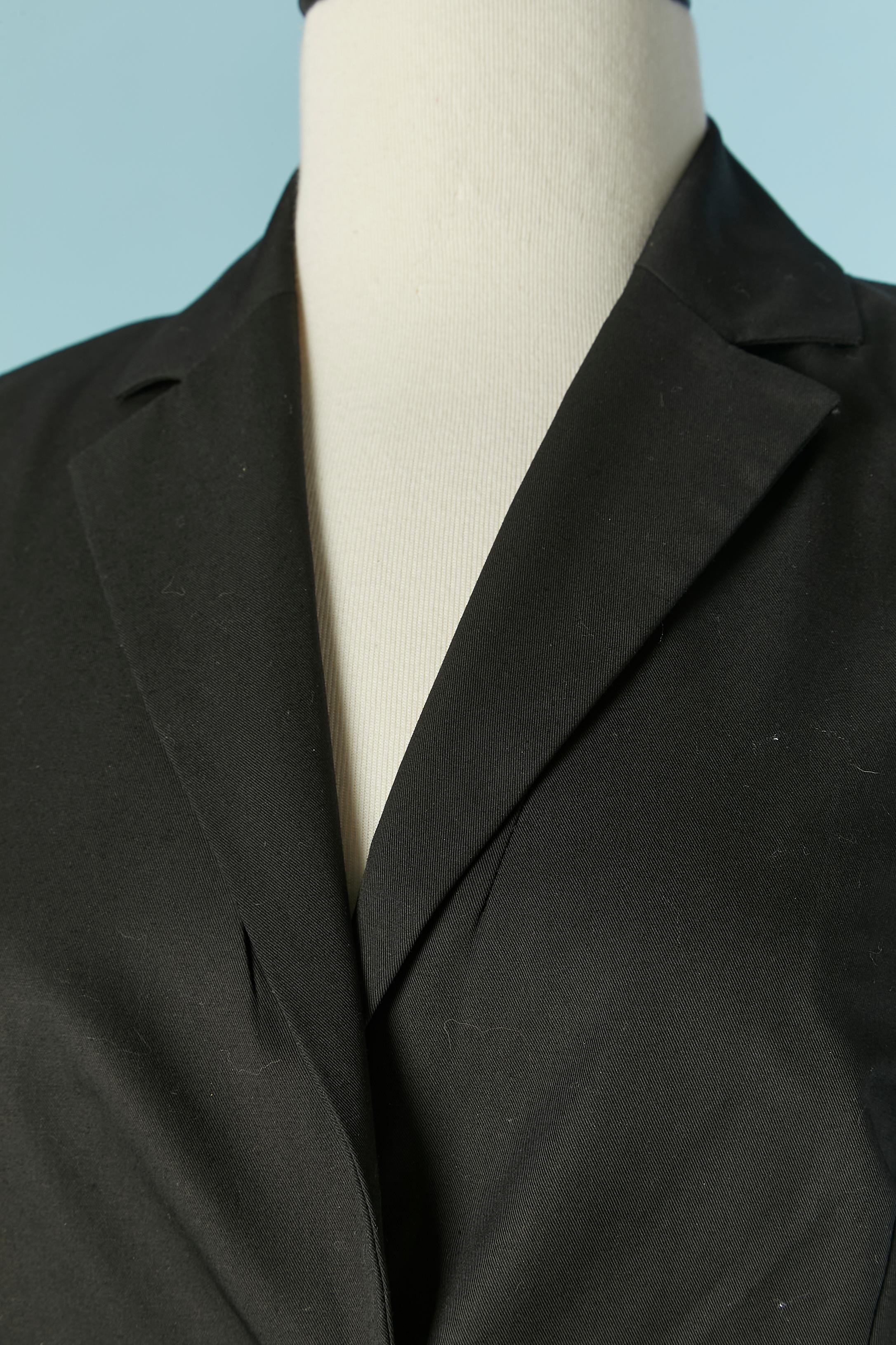 Black cotton skirt-suit with white laces. Fabric composition: 96% cotton, 4% elastane. Lining: 95% polyester, 5% elastane. 
Thin shoulder pad. One Branded button and buttonhole closure on the middle front and 3 buttons and buttonhole on the cuffs. 2