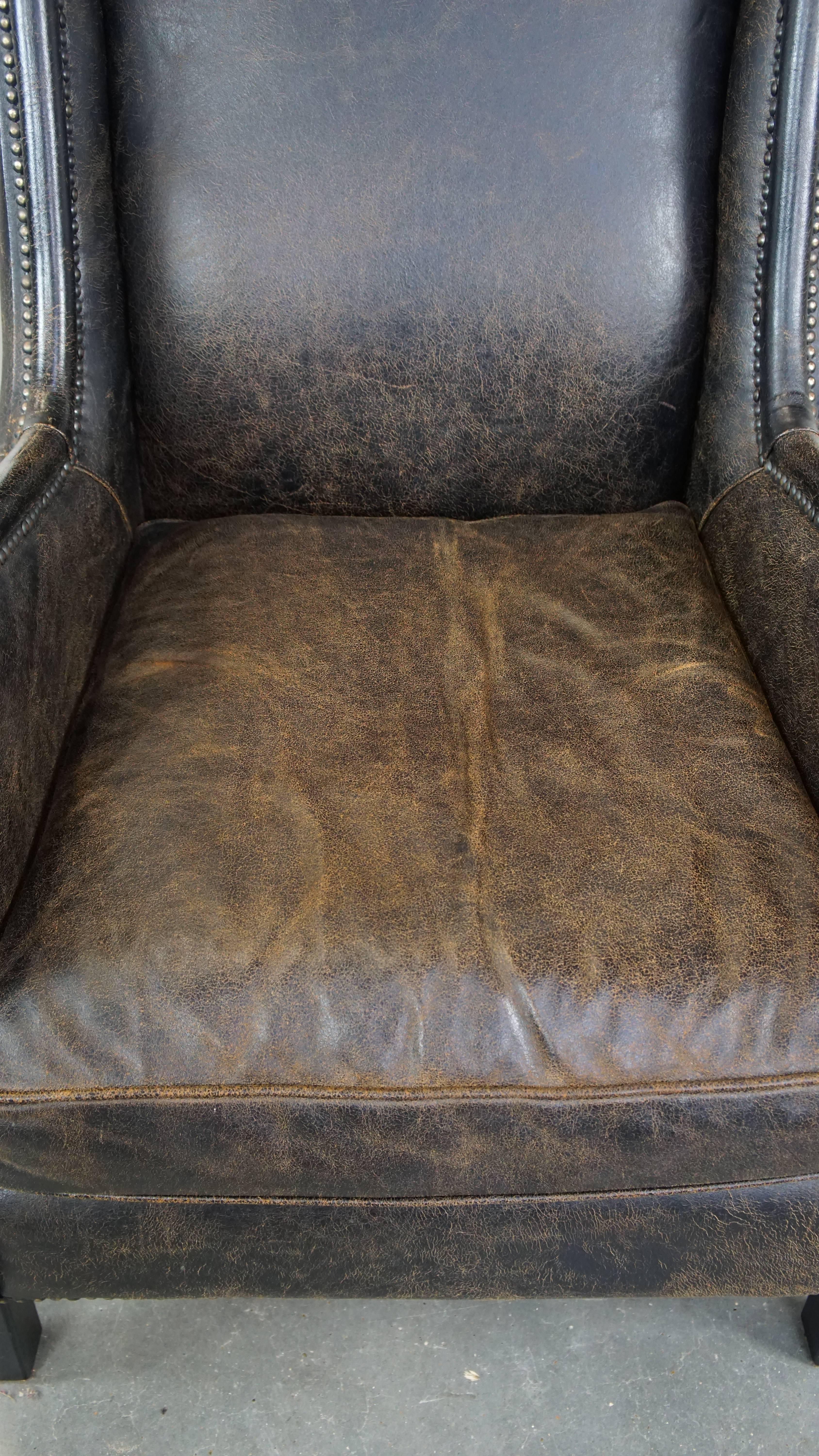 20th Century Black cow leather armchair finished with decorative nails, industrial style For Sale