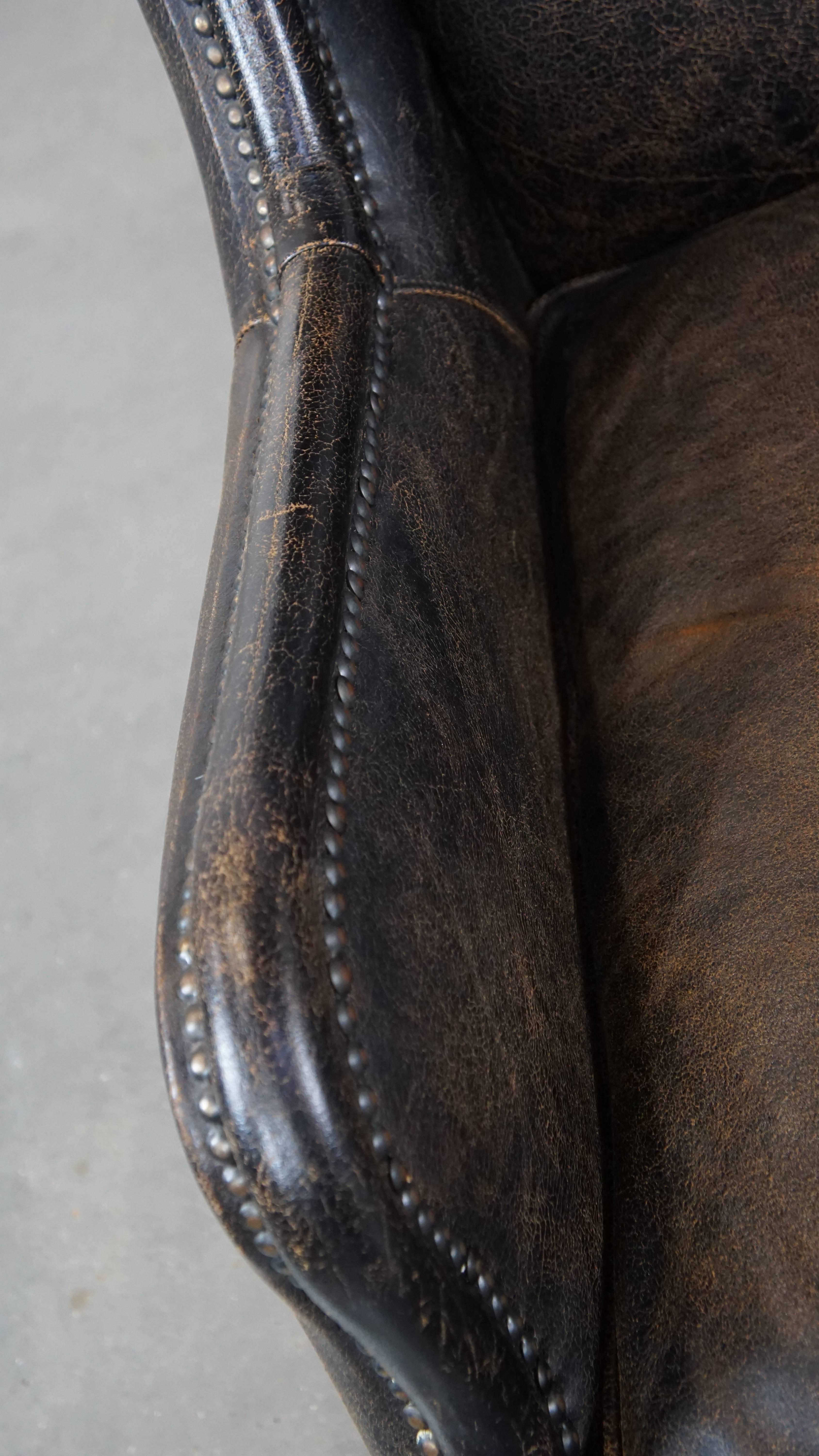 Cowhide Black cow leather armchair finished with decorative nails, industrial style For Sale