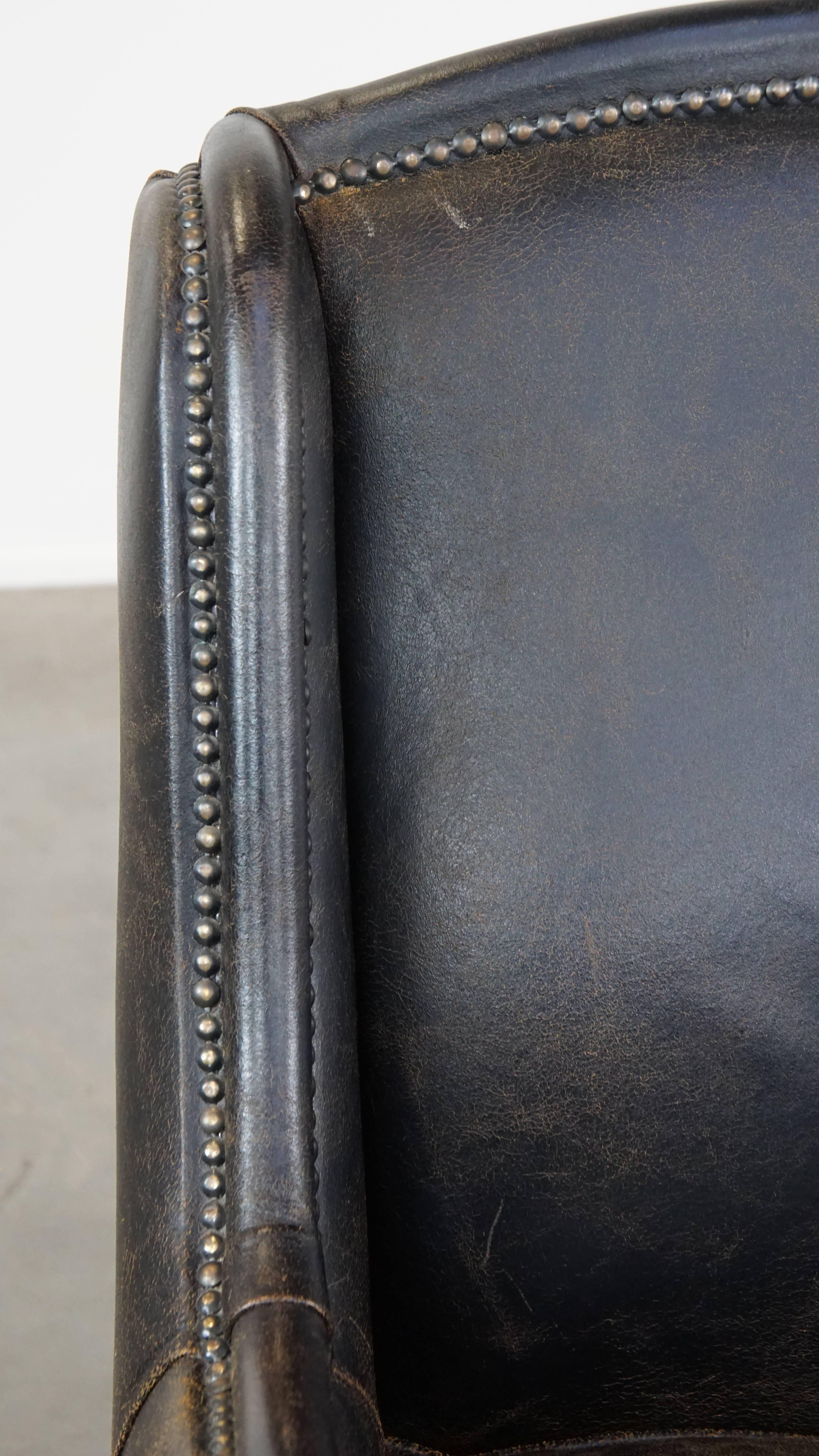 Black cow leather armchair in industrial style finished with decorative nails For Sale 3