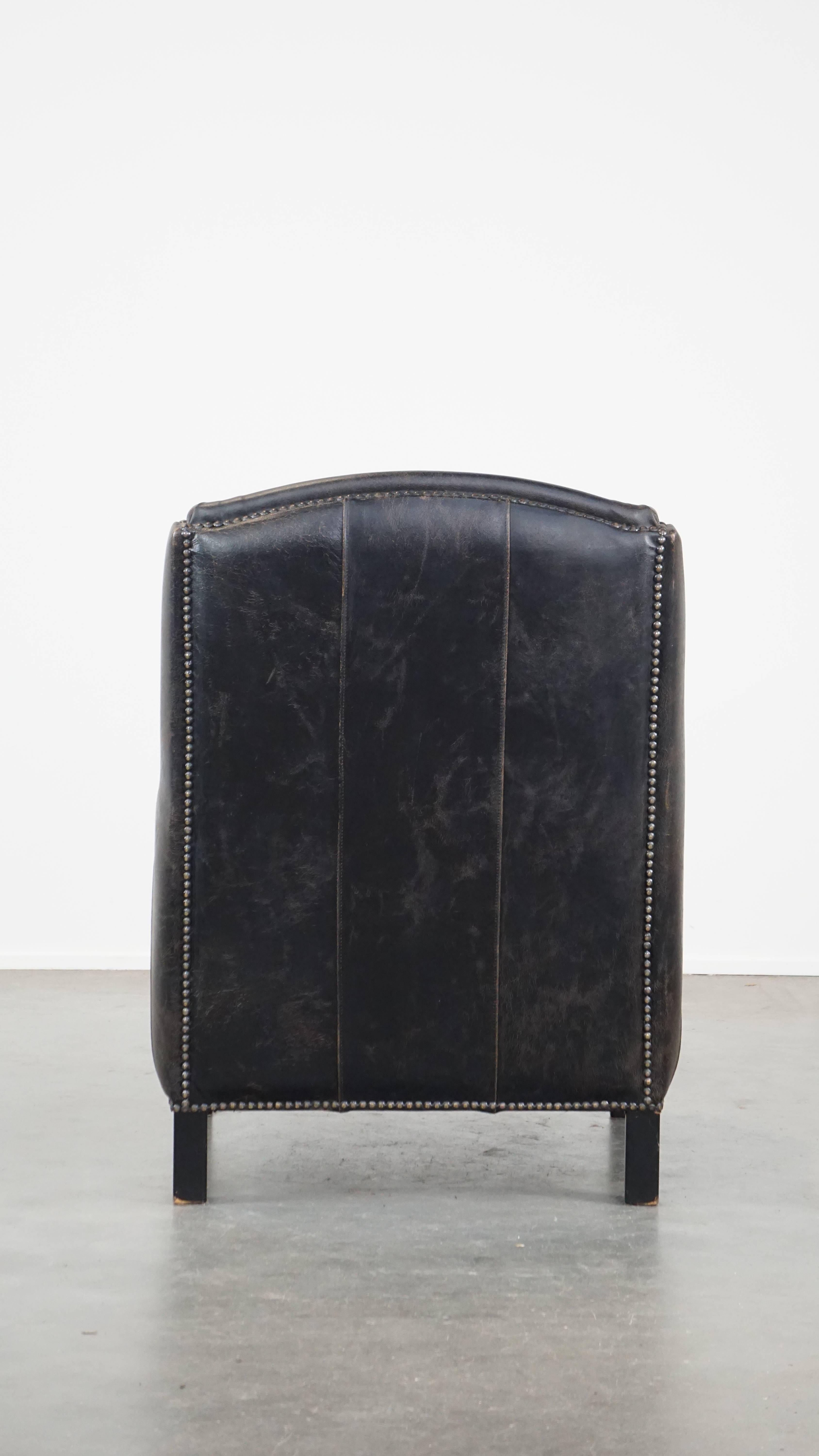 Hand-Crafted Black cow leather armchair in industrial style finished with decorative nails For Sale
