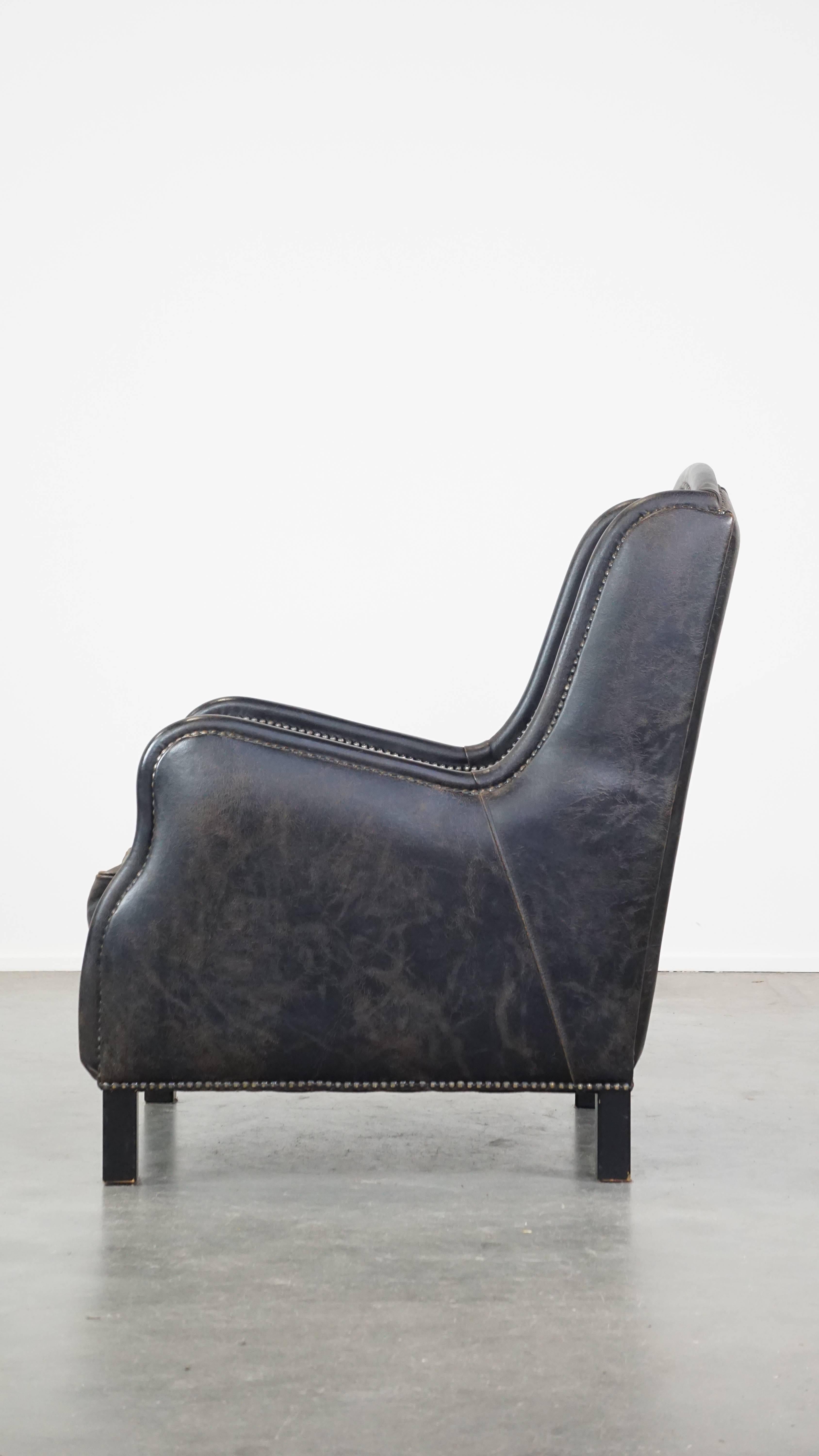 Black cow leather armchair in industrial style finished with decorative nails In Good Condition For Sale In Harderwijk, NL