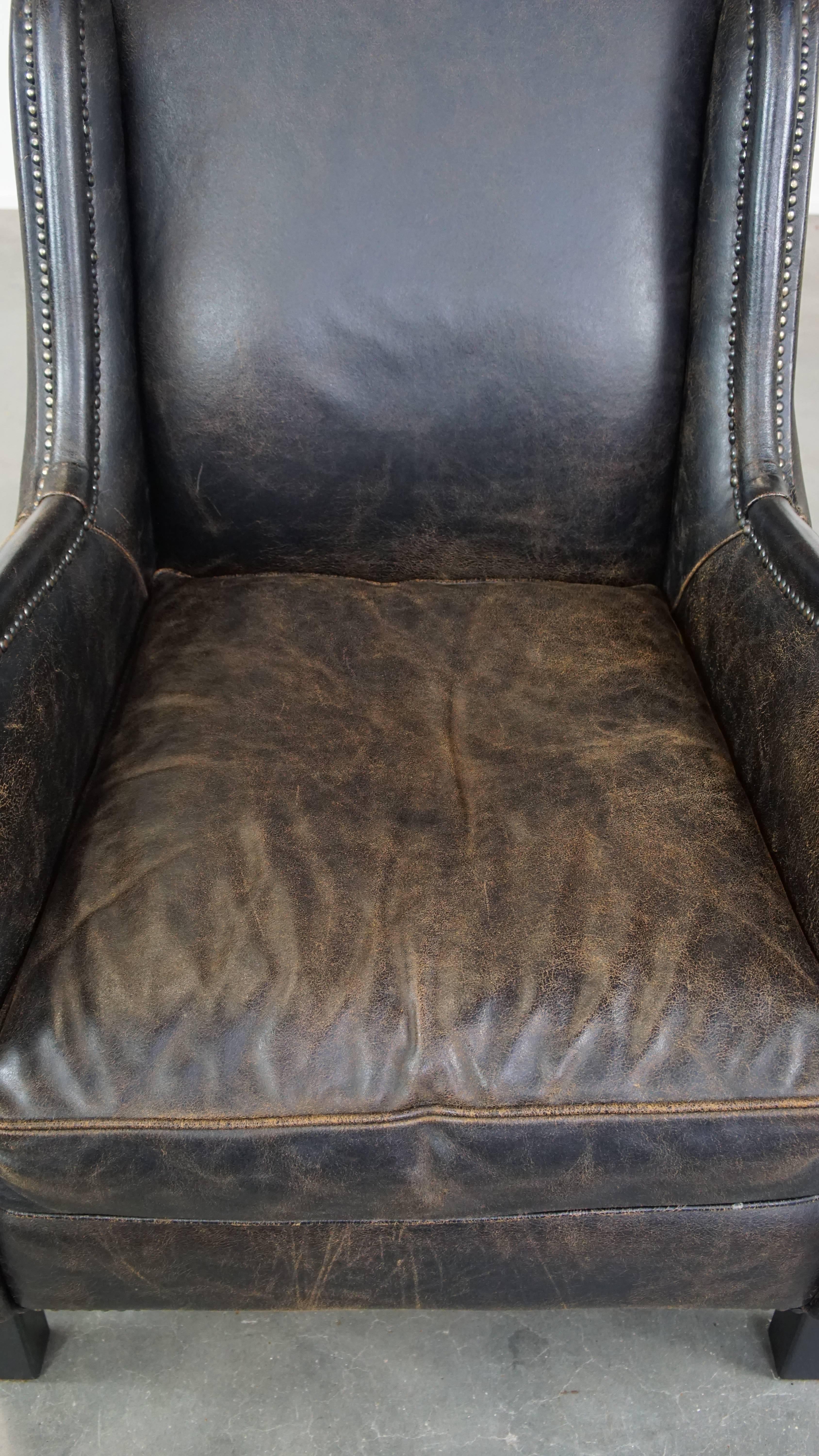 20th Century Black cow leather armchair in industrial style finished with decorative nails For Sale