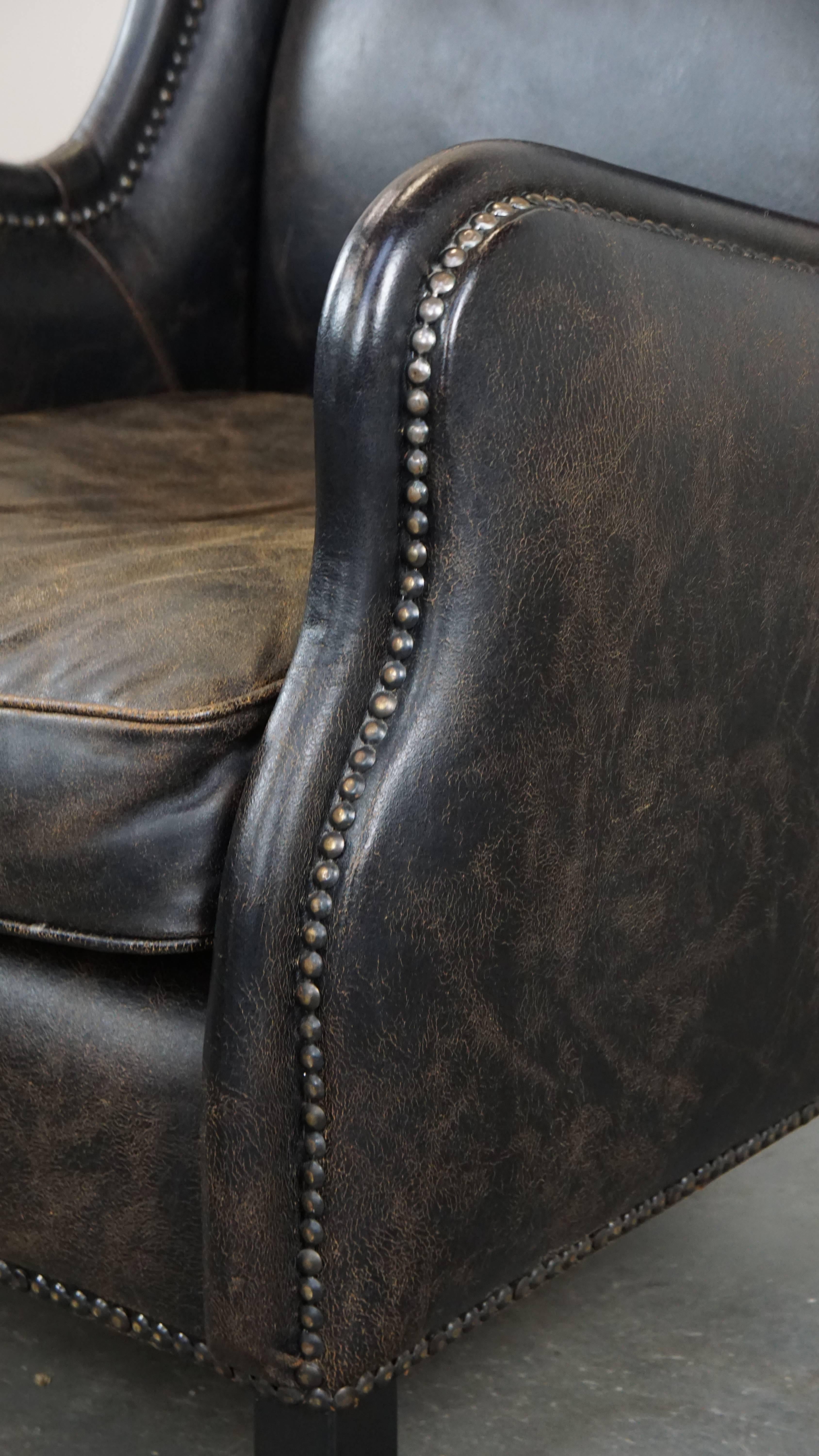Black cow leather armchair in industrial style finished with decorative nails For Sale 2
