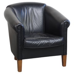Fauteuil club en cuir de vachette noir de style anglais avec un grand design luxueux.