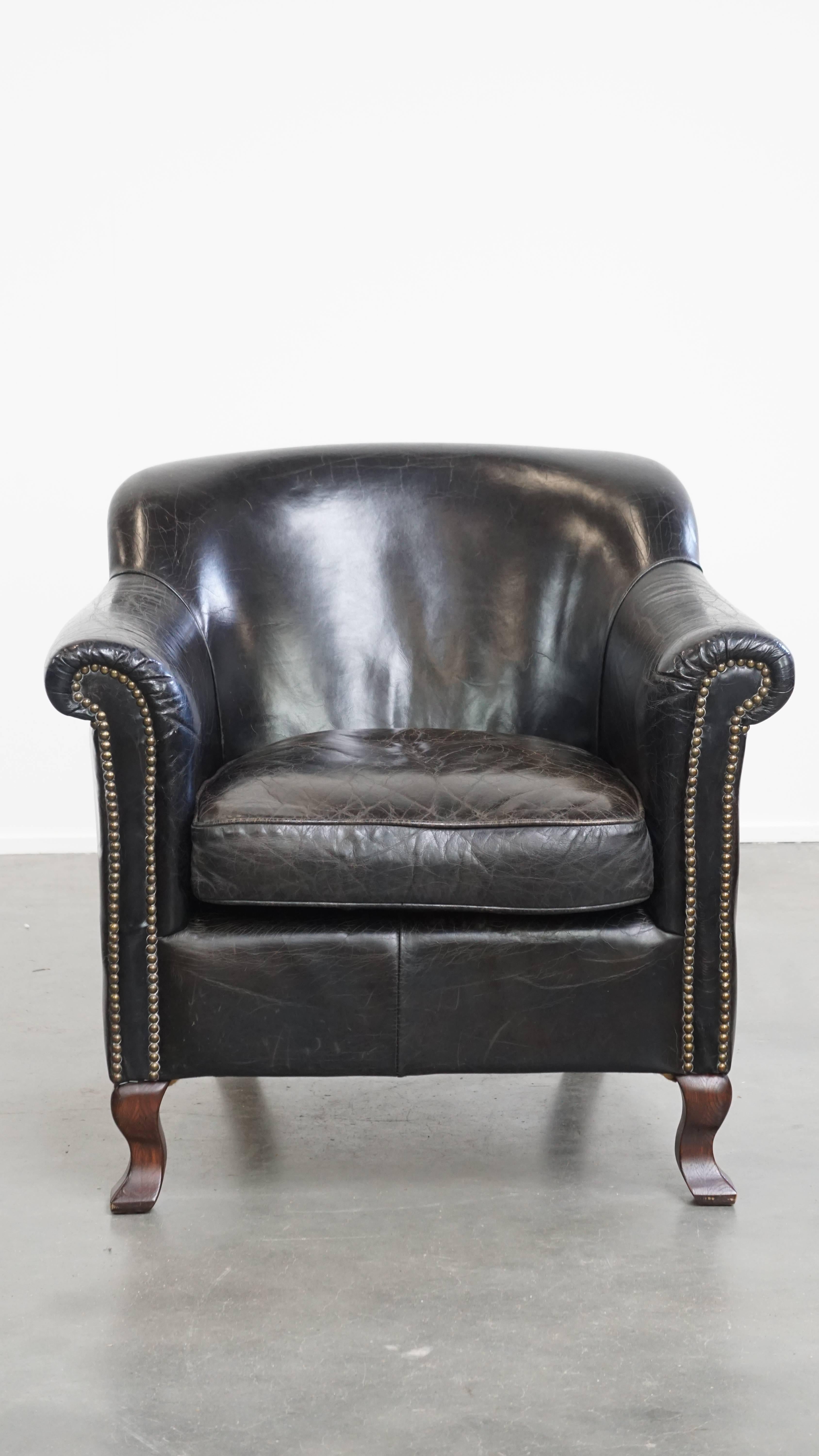 Offered here is this stunning and sturdy black cowhide leather armchair with an elegant design. This beautiful black leather armchair is crafted from characterful grained leather and features an attractive shape. In terms of style, it can be easily