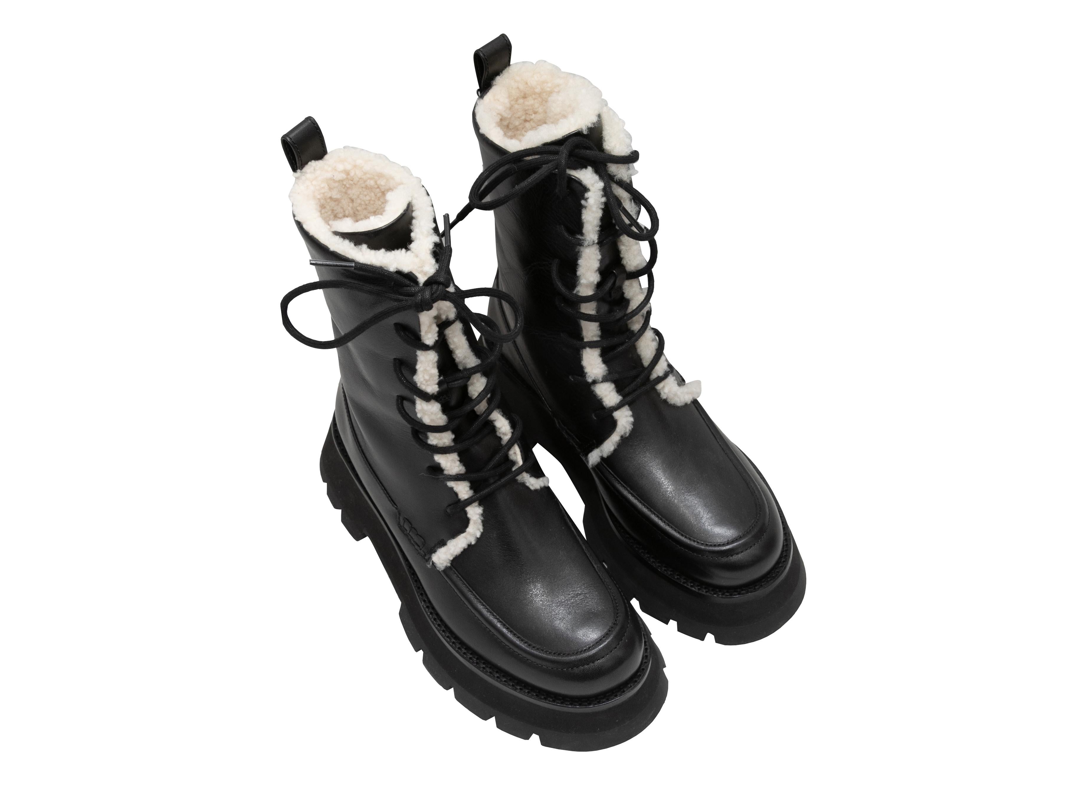 Black leather and cream shearling-lined Kate combat boots by 3.1 Phillip Lim. Foam rubber lug soles. Lace-up tie closures at tops. 7.5