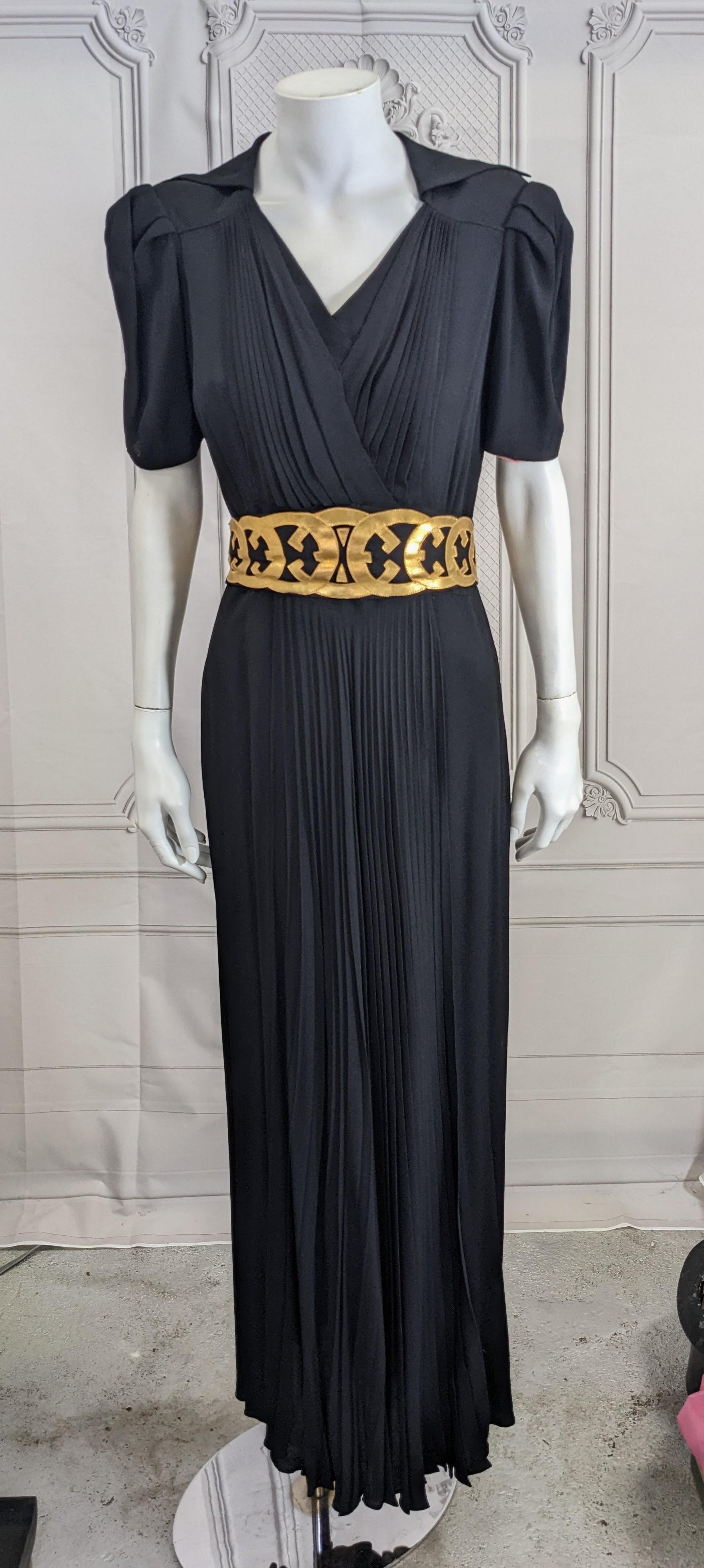 Black Rayon Crepe and Gold Kid Leather One Piece Deco Gown from the late 1930's, early 1940's. Pleated faux wrap design with large exaggerated collar and amazing gold kid applique Deco design belt. Large tucked shoulders with a pleated panel running
