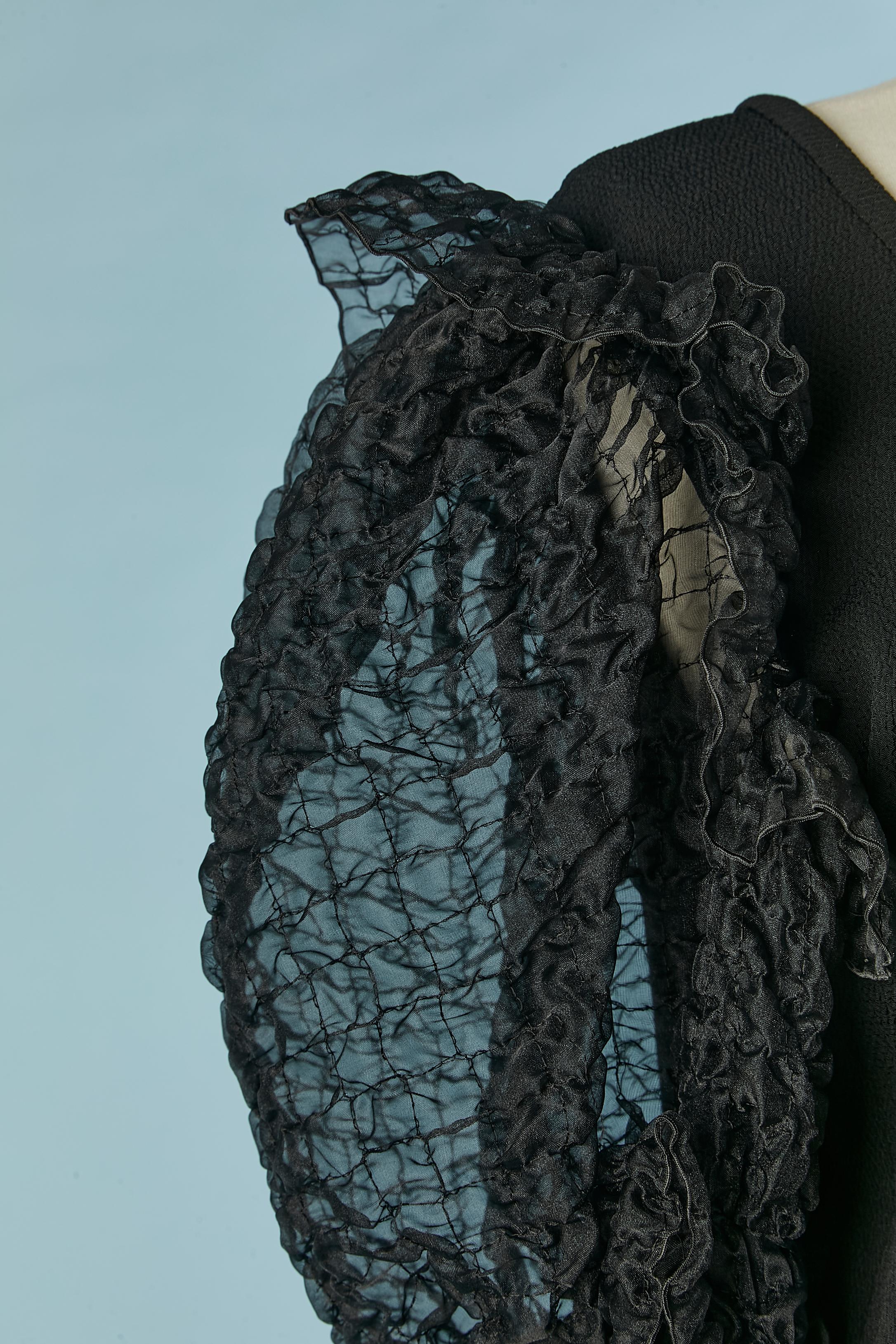 Schwarze Crêpe-Bluse mit Ballonärmeln. Zusammensetzung des Stoffes: 57% Viskose, 43% Acetat. 
Unsichtbarer Reißverschluss auf der linken Seite und Knopf und Knopfloch am Ende der Ärmel. 
GRÖSSE 40(Fr) 10 (Us) 