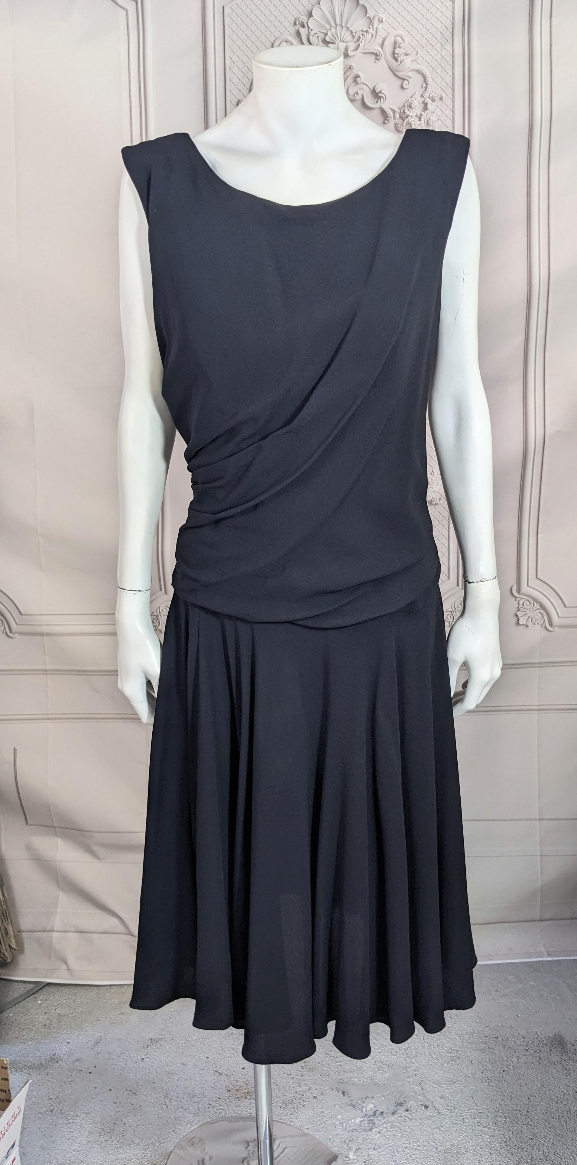 Schwarzes, drapiertes und ausgestelltes Mid-Century-Kleid aus den 1960er-Jahren aus Krepp. Locker geschnittenes Mieder mit Biesen, die vom Rücken nach vorne verlaufen. Der ausgestellte Rock ist sehr voll und kontrastiert mit dem drapierten Oberteil.