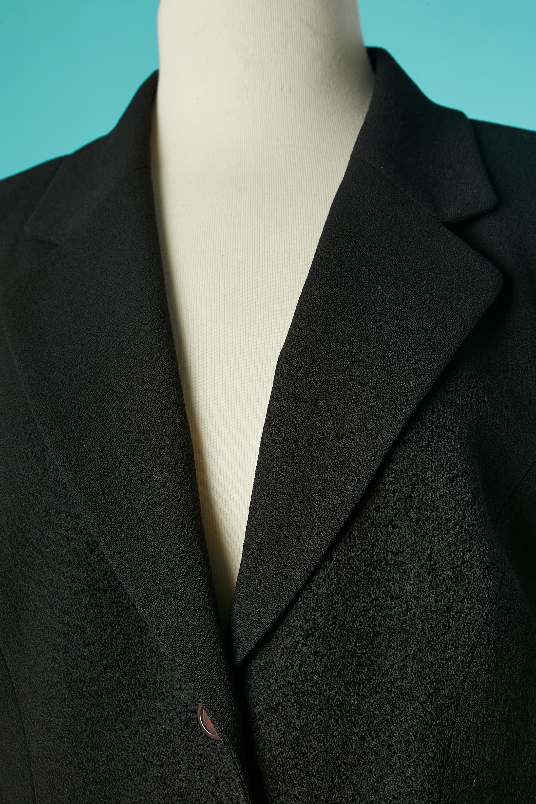 Einreihige Jacke aus schwarzem Crêpe mit einer Vollstickerei  Ärmel. Die Stickerei wird mit Perlen, Pailletten, Chiffon und Faden ausgeführt. Tasche auf beiden Seiten. 
Keine Stoff-Tag-Zusammensetzung, aber das Futter ist wahrscheinlich Viskose.