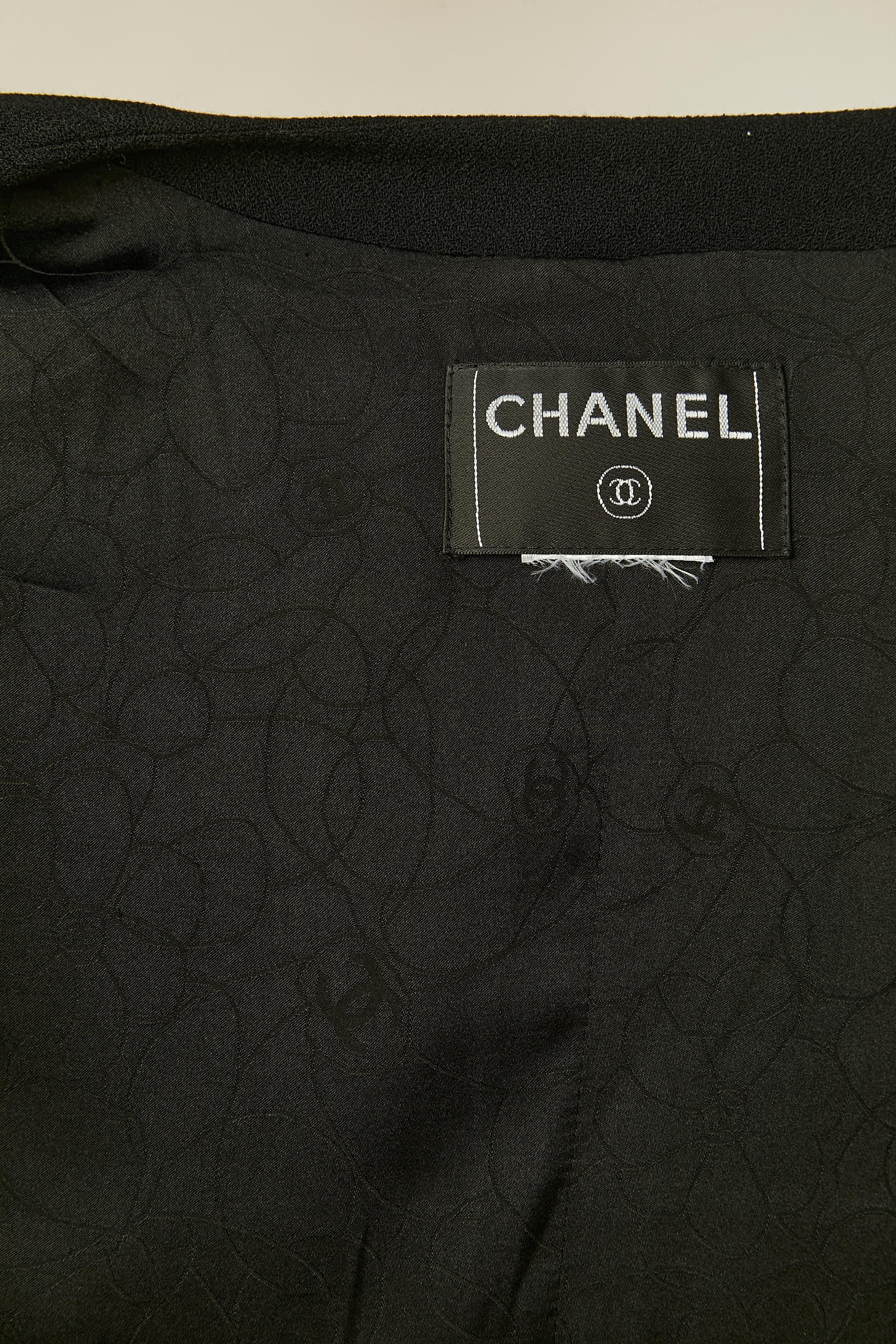 Black crêpe skirt-suit with double breasted jacket. Silk branded lining. Branded button and buttonhole closure on the front of the jacket and on the cuffs. 4 pockets on the front of the jacket. Some cuffs were attached to the sleeve bottom edge but