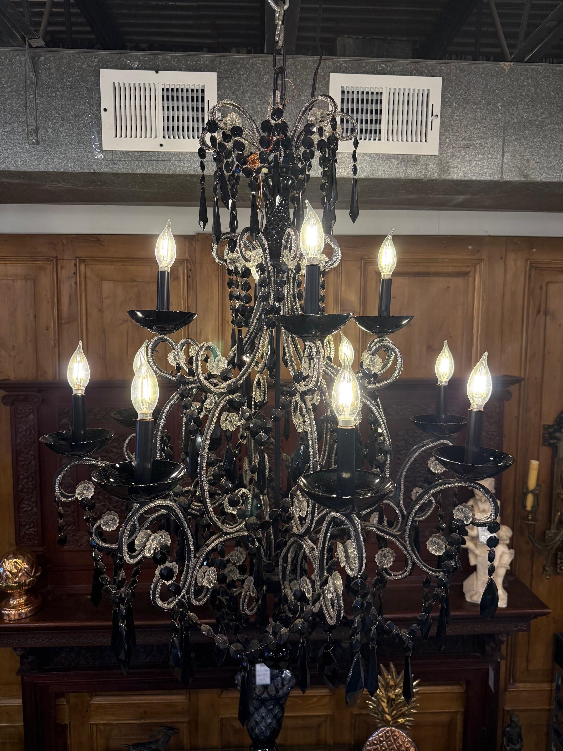 Un elegante lampadario in cristallo nero, dodici luci a due livelli con bordature in cristallo trasparente. Si tratta di un bellissimo lampadario in cristallo nero con dodici luci a candelabro e bordature in cristallo trasparente su ogni braccio. 
