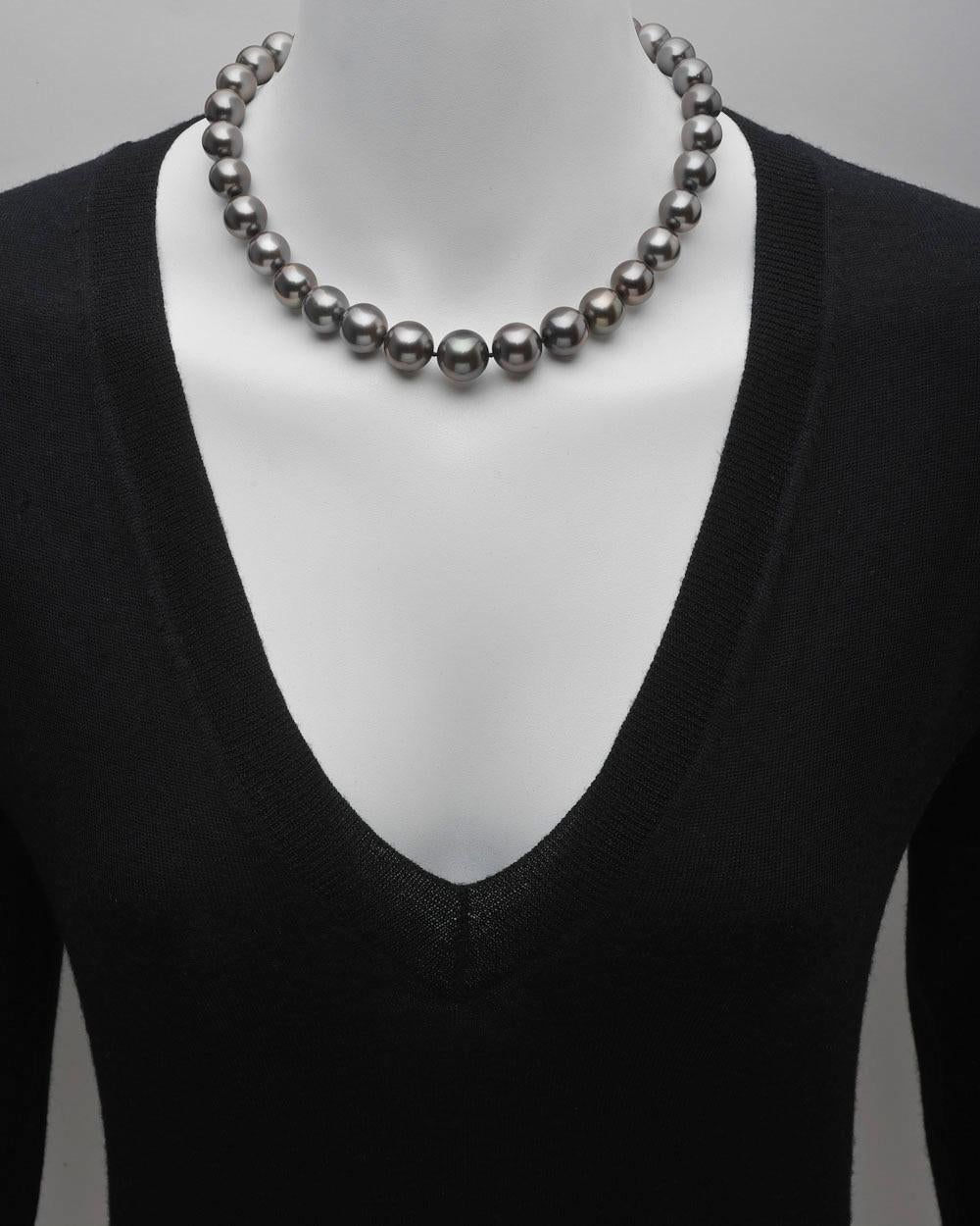 Single strand black pearl necklace, composed of 33 cultured pearls ranging from 14.8 to 12mm in diameter and strung on a silk cord, secured by a diamond and platinum ball clasp pavé-set with approximately 4.98 total carats of diamonds. 18.5